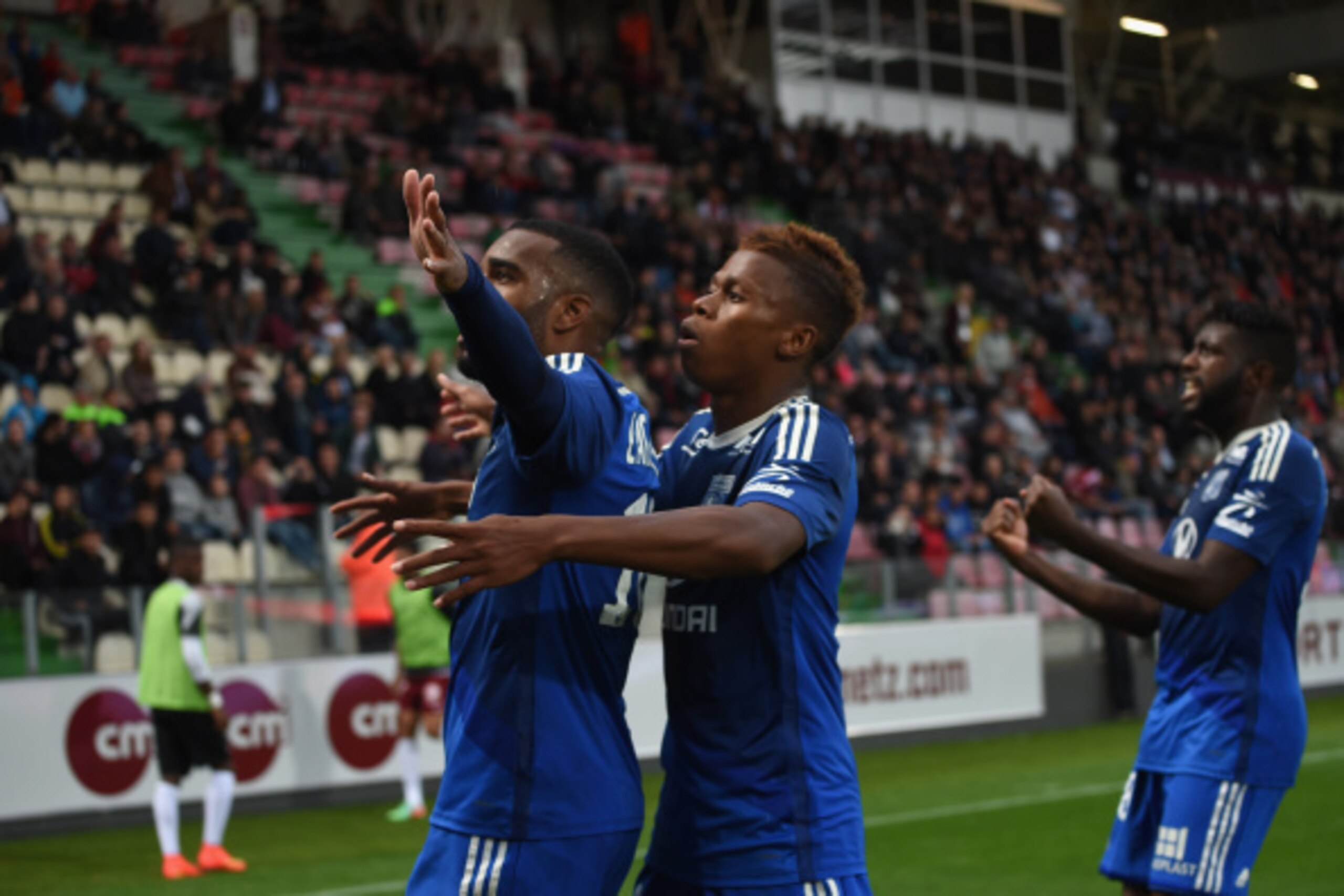 METZ, FRANCE - AUGUST 31: Alexandre Lacazette (L) of Lyon celebrates scoring his team's first goal with his teammates Clinton N'Jie (C) and Arnold Mvuemba (R) during the French Ligue 1 match between FC Metz and Olympique Lyonnais at Stade Saint-Symphorie METZ, FRANCE - AUGUST 31: Alexandre Lacazette (L) of Lyon celebrates scoring his team's first goal with his teammates Clinton N'Jie (C) and Arnold Mvuemba (R) during the French Ligue 1 match between FC Metz and Olympique Lyonnais at Stade Saint-Symphorie