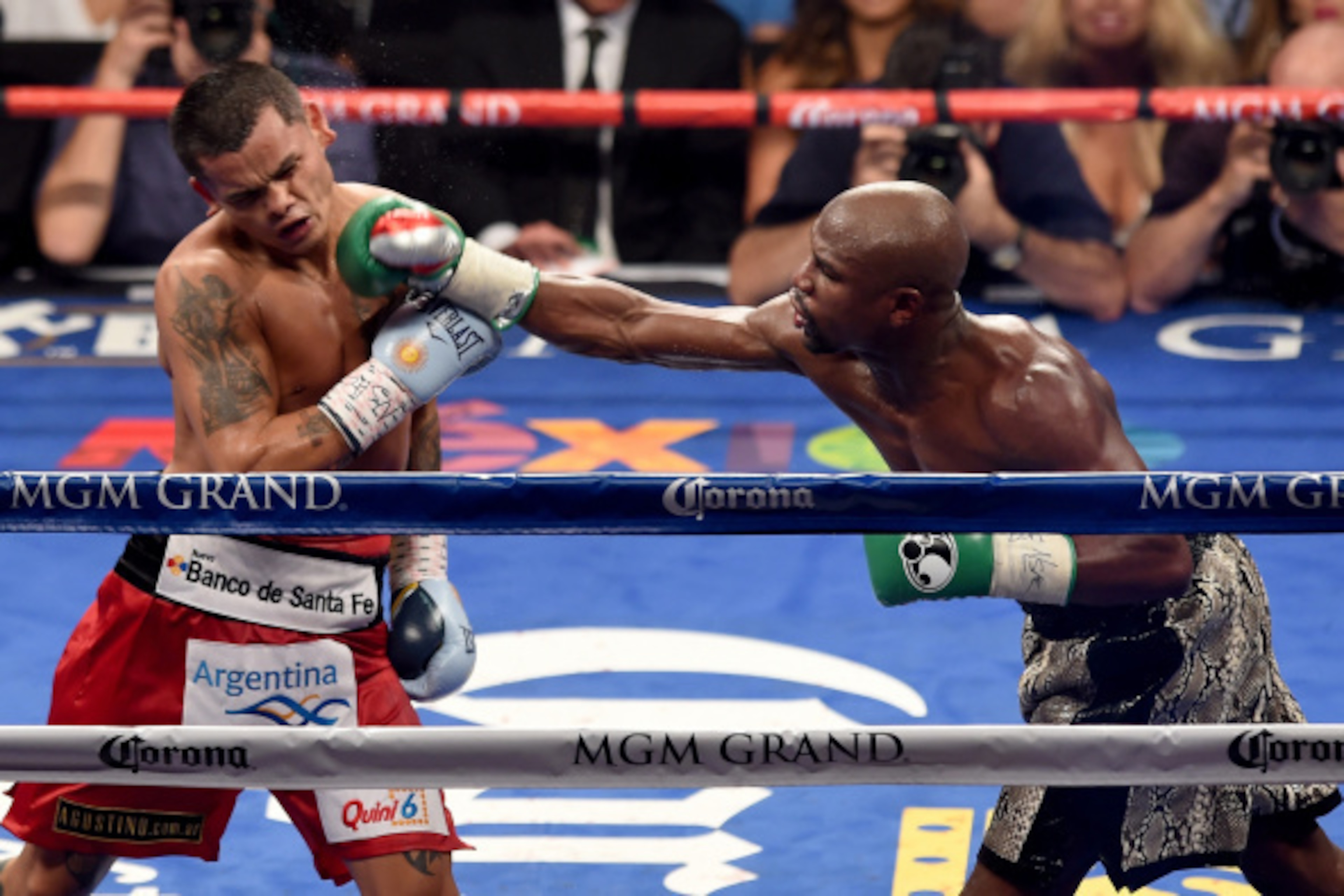 LAS VEGAS, NV - SEPTEMBER 13:  (R-L) Floyd Mayweather Jr. throws a right to the face of Marcos Maidana during their WBC/WBA welterweight title fight at the MGM Grand Garden Arena on September 13, 2014 in Las Vegas, Nevada.  (Photo by Ethan Miller/Getty Im