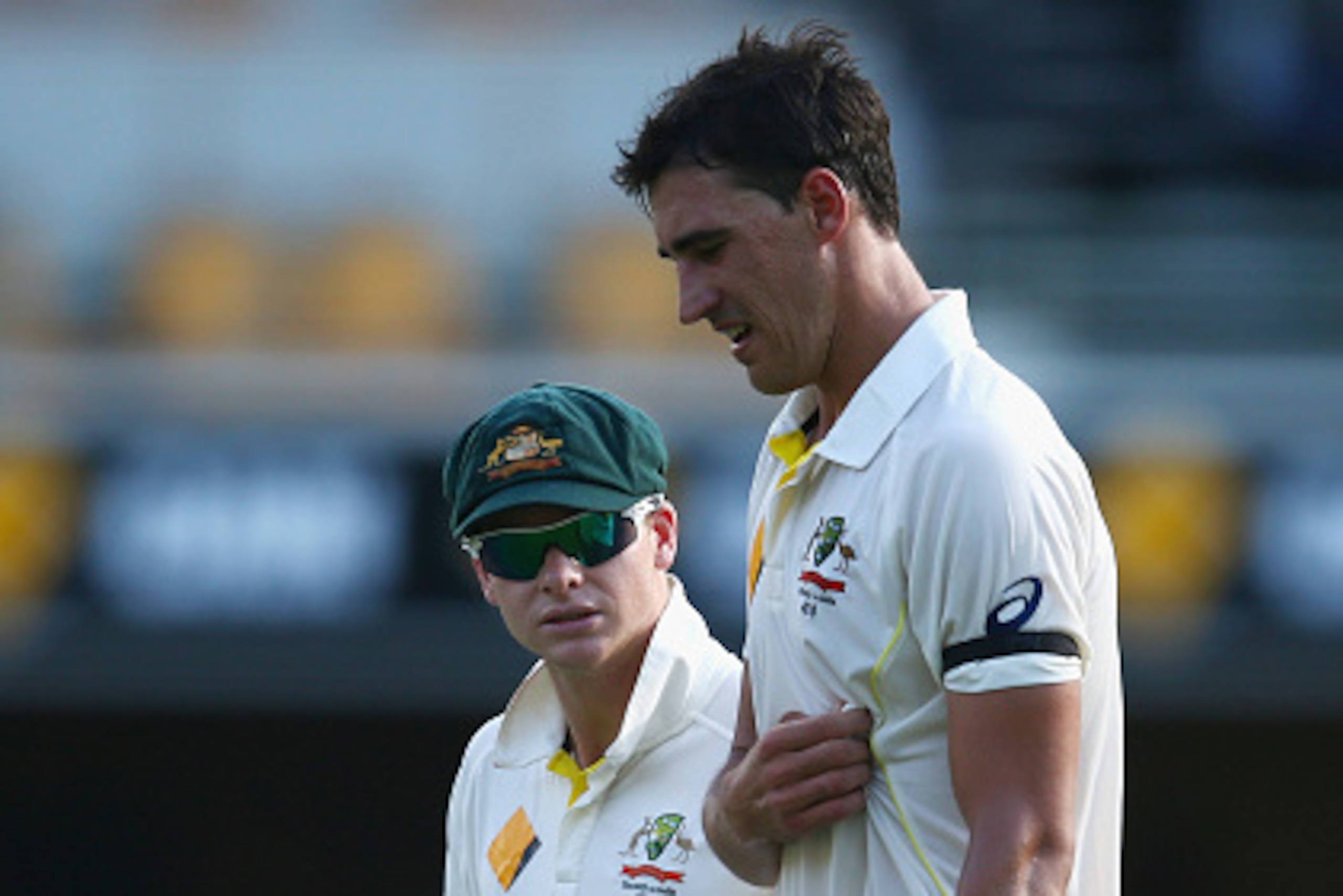 BRISBANE, AUSTRALIA - DECEMBER 17: Australian captain Steve Smith checks on team mate Mitchell Starc during day one of the 2nd Test match between Australia and India at The Gabba on December 17, 2014 in Brisbane, Australia.  (Photo by Cameron Spencer/Gett