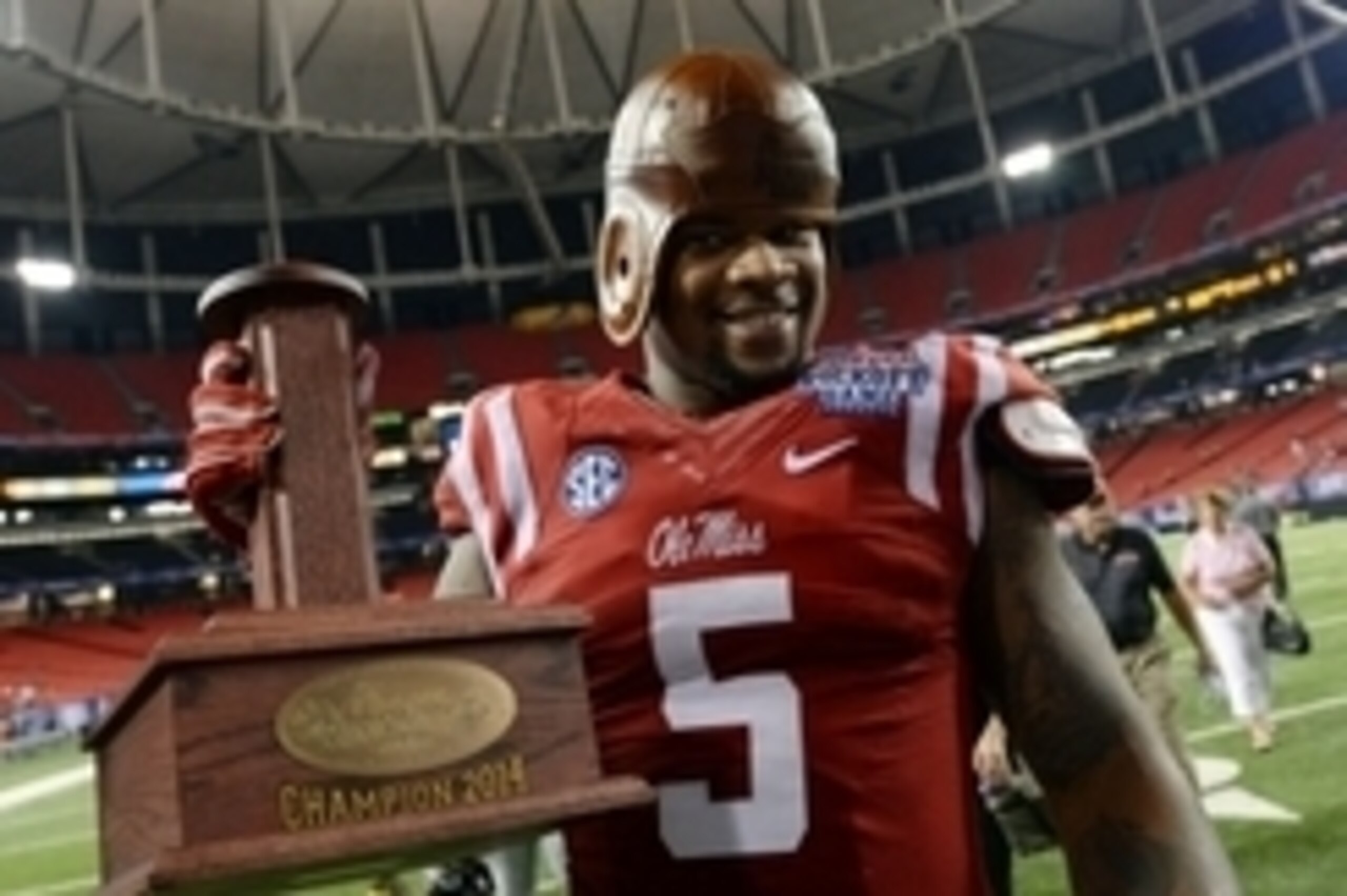 Aug 28, 2014; Atlanta, GA, USA; Mississippi Rebels defensive tackle Robert Nkemdiche (5) celebrates with the old leather helmet after defeating the Boise State Broncos in the 2014 Chick-fil-A kickoff game at the Georgia Dome. Rebels won 35-13. Mandatory C