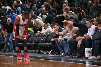 BROOKLYN, NY - DECEMBER 16:  Dwyane Wade #3 of the Miami Heat chats with Brooklyn Nets fans during the game on December 16, 2014 at Barclays Center in Brooklyn, New York. NOTE TO USER: User expressly acknowledges and agrees that, by downloading and or usi