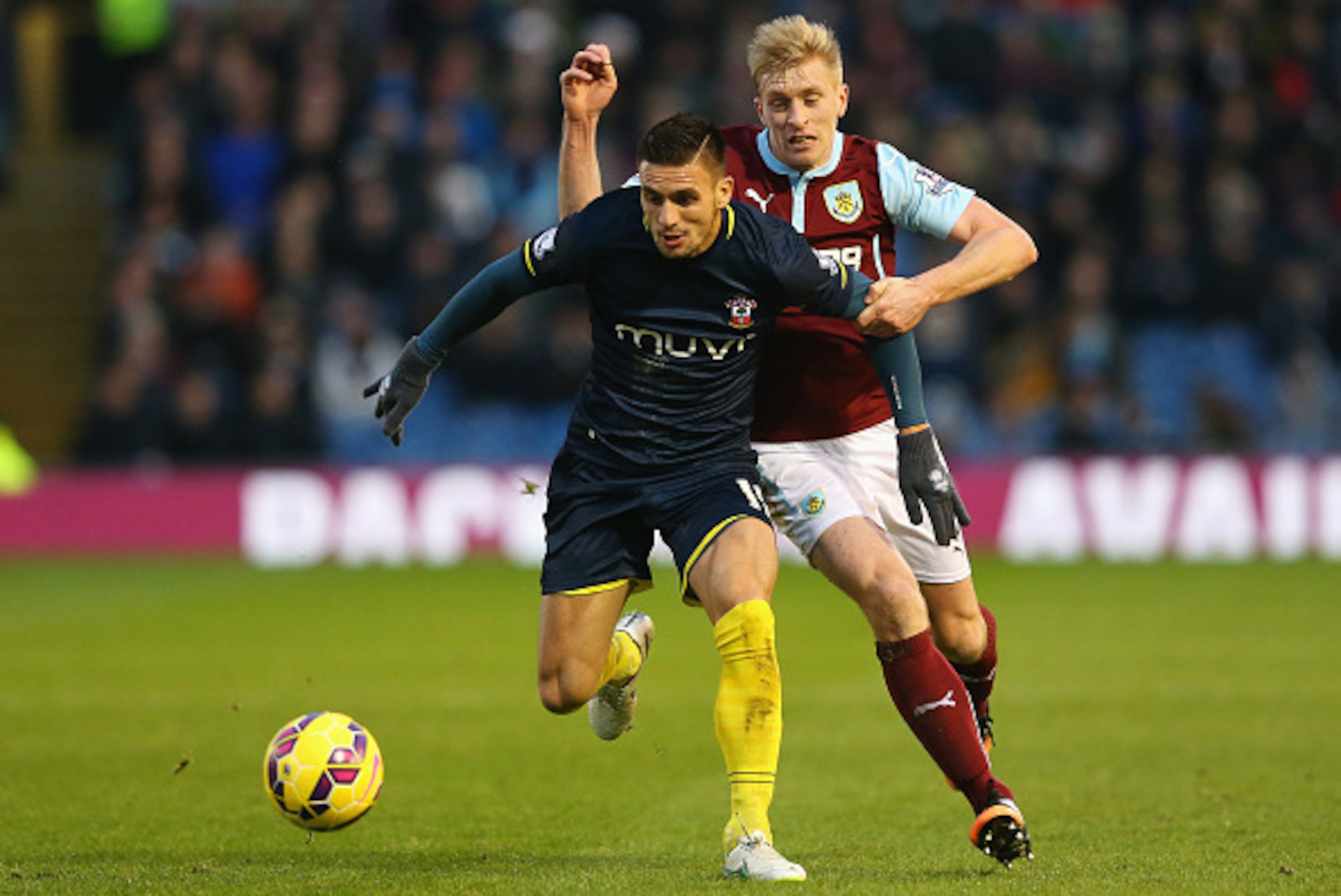 BURNLEY, ENGLAND - DECEMBER 13:  Ben Mee of Burnley challenges for the ball with Dusan Tadic of Southampton during the Barclays Premier League match between Burnley and Southampton at Turf Moor on December 13, 2014 in Burnley, England.  (Photo by Alex Liv