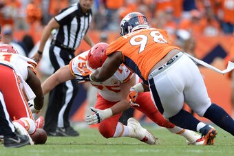 Sep 14, 2014; Denver, CO, USA; Kansas City Chiefs center Rodney Hudson (61) and guard Mike McGlynn (75) attempt to recover a fumble away from defensive tackle Terrance Knighton (98) late in the fourth quarter at Sports Authority Field at Mile High. The Br