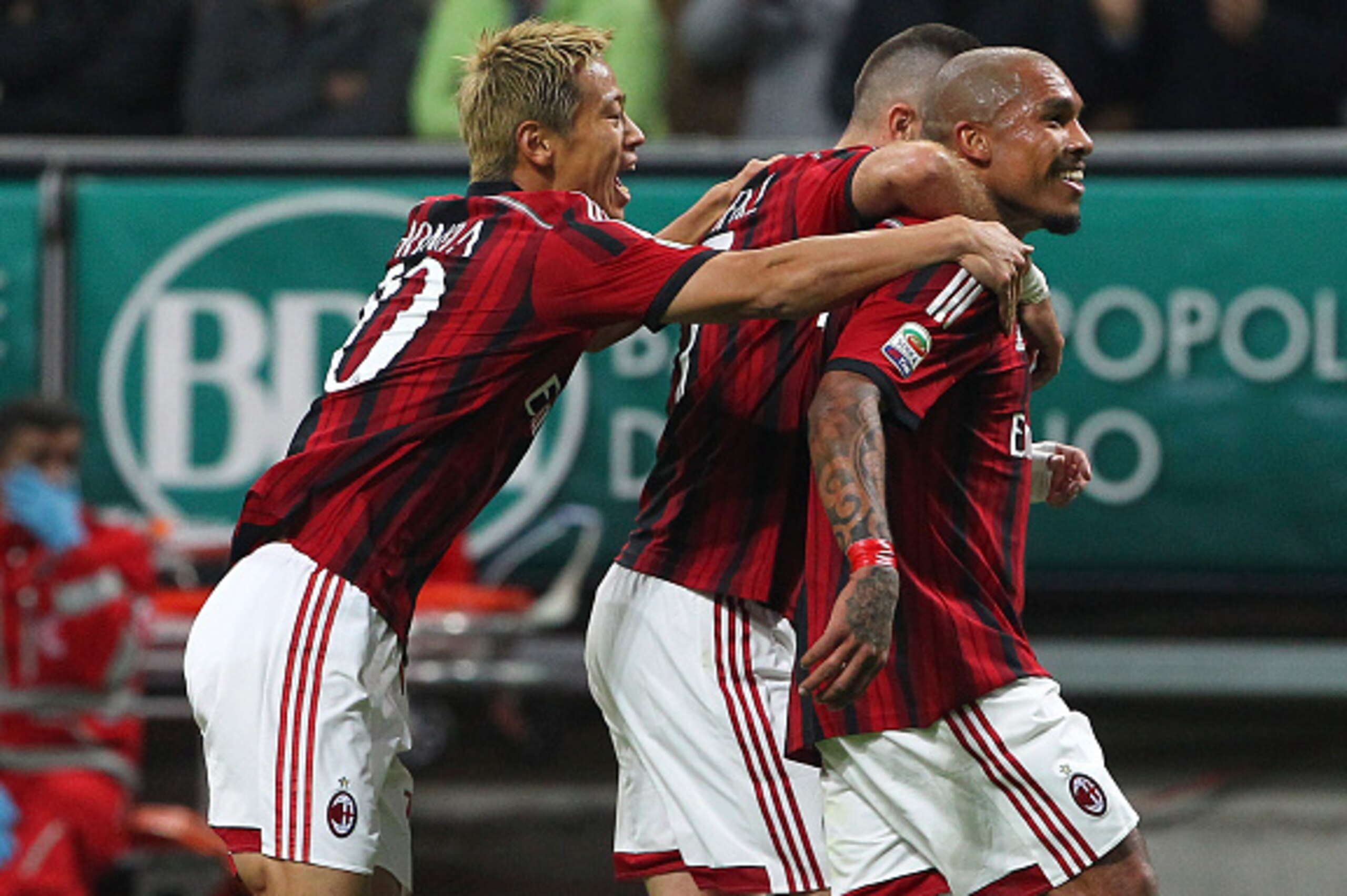 MILAN, ITALY - OCTOBER 26:  Nigel De Jong (R) of AC Milan celebrates with his team-mates Jeremy Menez (C) and Keisuke Honda (L) after scoring the opening goal during the Serie A match between AC Milan and ACF Fiorentina at Stadio Giuseppe Meazza on Octobe