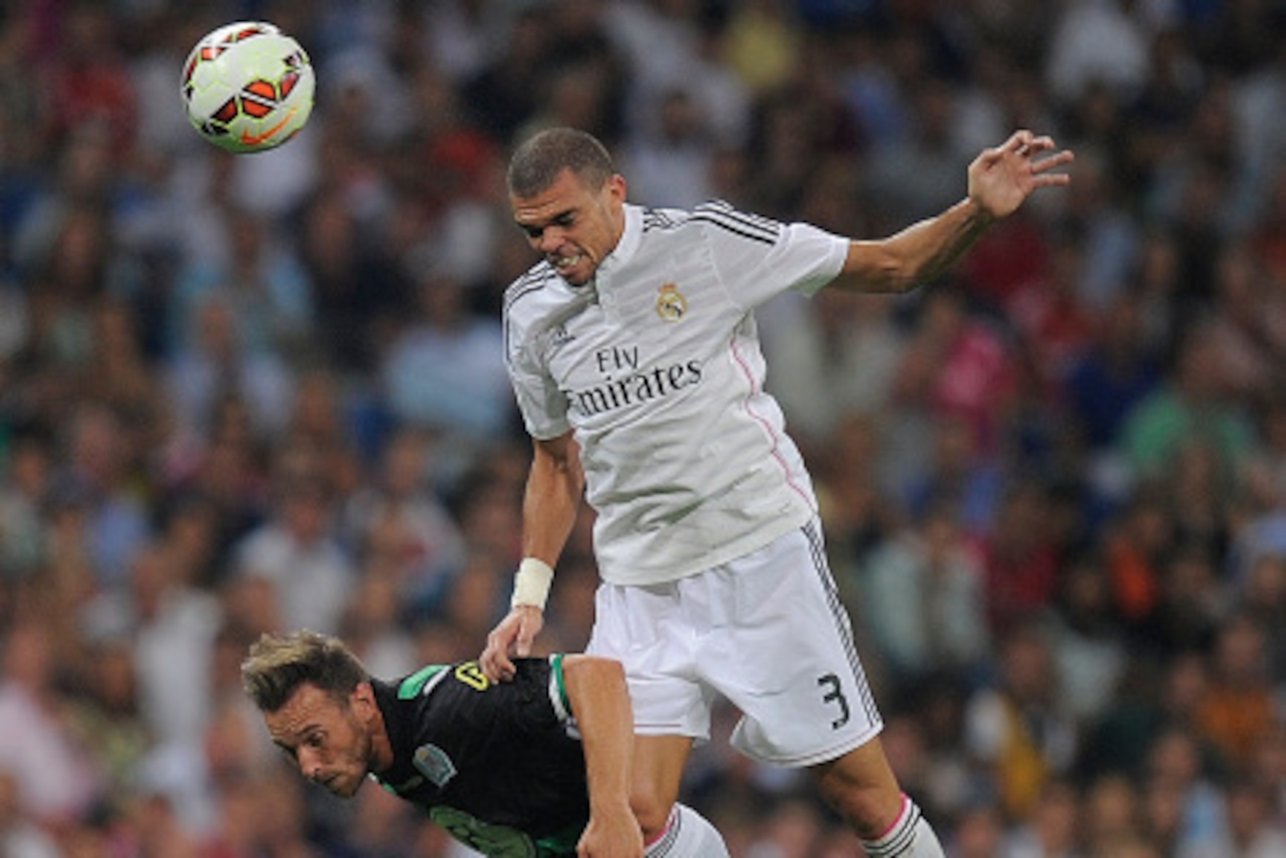 MADRID, SPAIN - AUGUST 25:  Pepe of Real Madrid CF heads the ball while being challenged by Francisco Jimenez Tejada alias Xisco of Cordoba CF during the La liga match between Real Madrid CF and Cordoba CF at Estadio Santiago Bernabeu on August 25, 2014 i