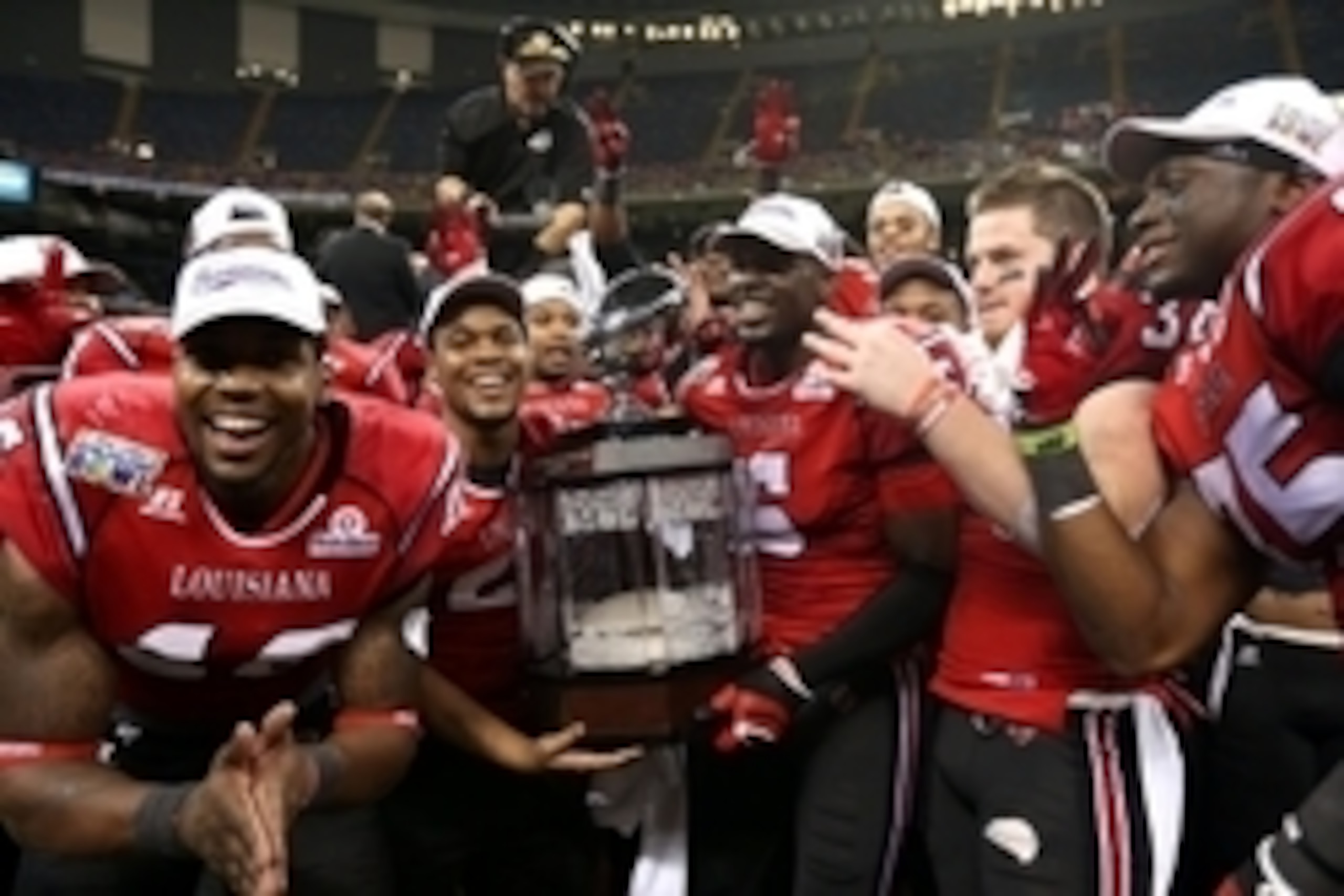 Dec 21, 2013; New Orleans, LA, USA; Louisiana-Lafayette Ragin Cajuns players celebrate with the R&L Carriers New Orleans Bowl trophy after they defeated the Tulane Green Wave, 24-21, at the Mercedes-Benz Superdome. Mandatory Credit: Chuck Cook-USA TODAY S