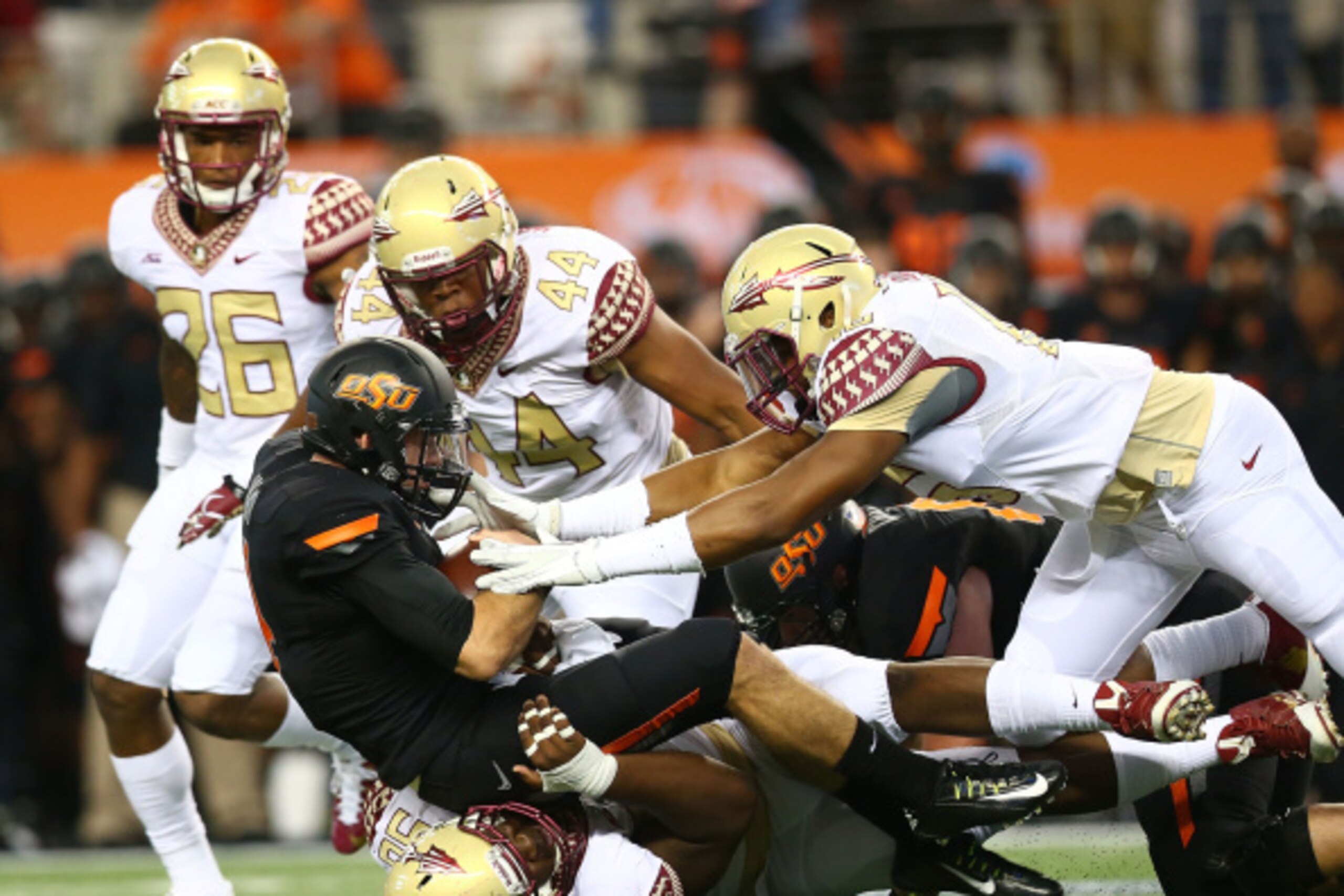 ARLINGTON, TX - AUGUST 30:  J.W. Walsh #4 of the Oklahoma State Cowboys is sacked by Cam Ponder #44 of the Florida State Seminoles and Eddie Goldman #90 of the Florida State Seminoles in the first half of the Advocare Cowboys Classic at AT&T Stadium on Au