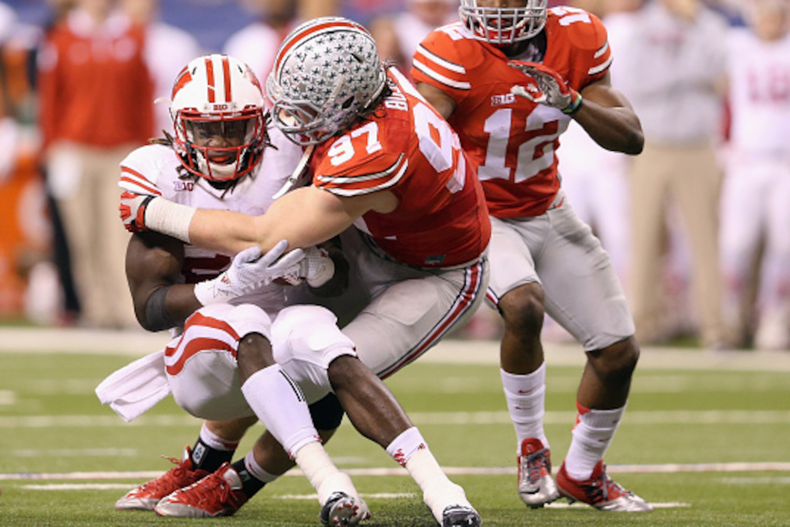 INDIANAPOLIS, IN - DECEMBER 06:  Joey Bosa #97 of the Ohio State Buckeyes tackles Melvin Gordon #25 of the Wisconsin Badgers in the first half of the Big Ten Championship at Lucas Oil Stadium on December 6, 2014 in Indianapolis, Indiana.  (Photo by Andy L