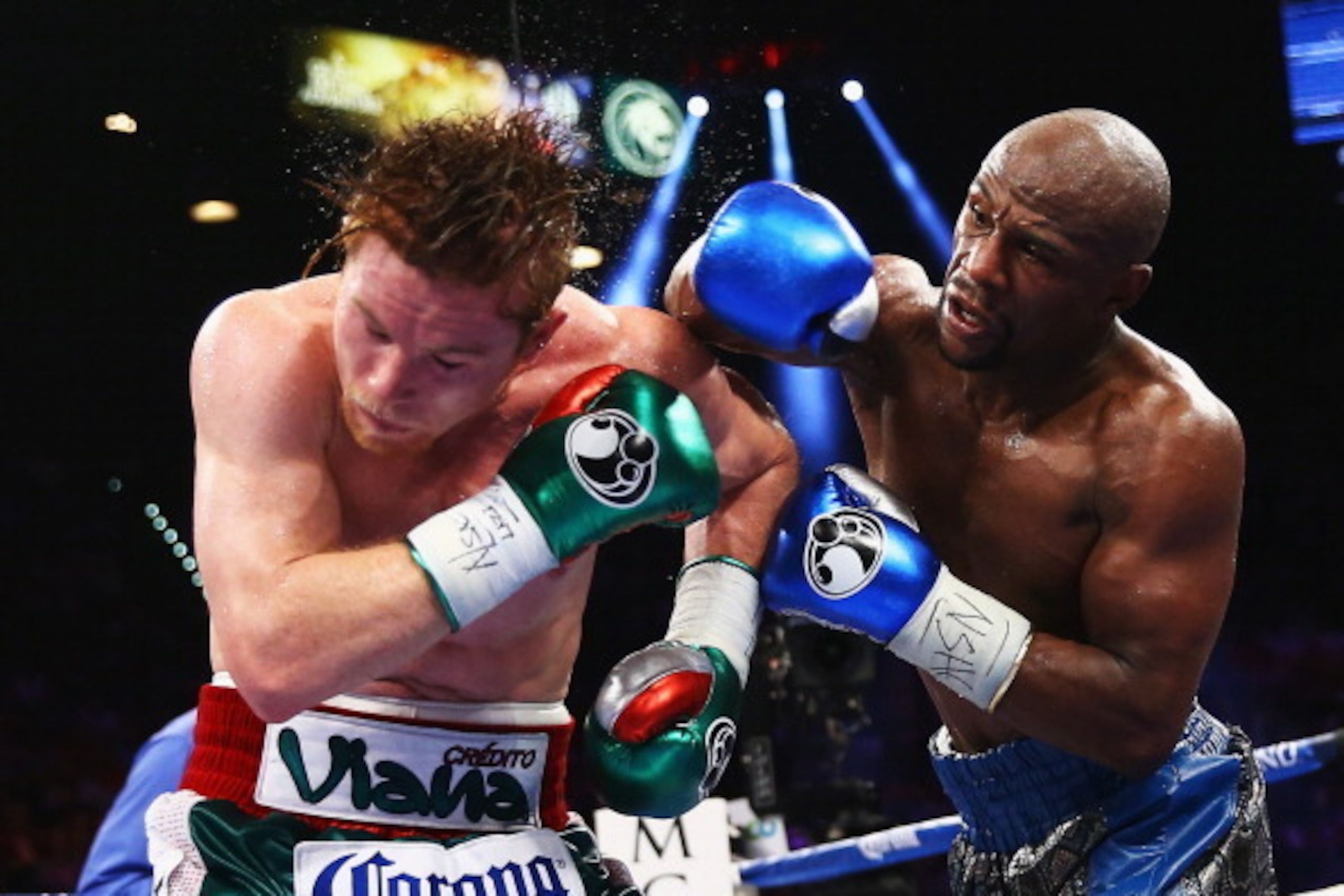 LAS VEGAS, NV - SEPTEMBER 14: (L-R) Floyd Mayweather Jr. throws a right to Canelo Alvarez during their WBC/WBA 154-pound title fight at the MGM Grand Garden Arena on September 14, 2013 in Las Vegas, Nevada. (Photo by Al Bello/Getty Images) LAS VEGAS, NV - SEPTEMBER 14: (L-R) Floyd Mayweather Jr. throws a right to Canelo Alvarez during their WBC/WBA 154-pound title fight at the MGM Grand Garden Arena on September 14, 2013 in Las Vegas, Nevada. (Photo by Al Bello/Getty Images)