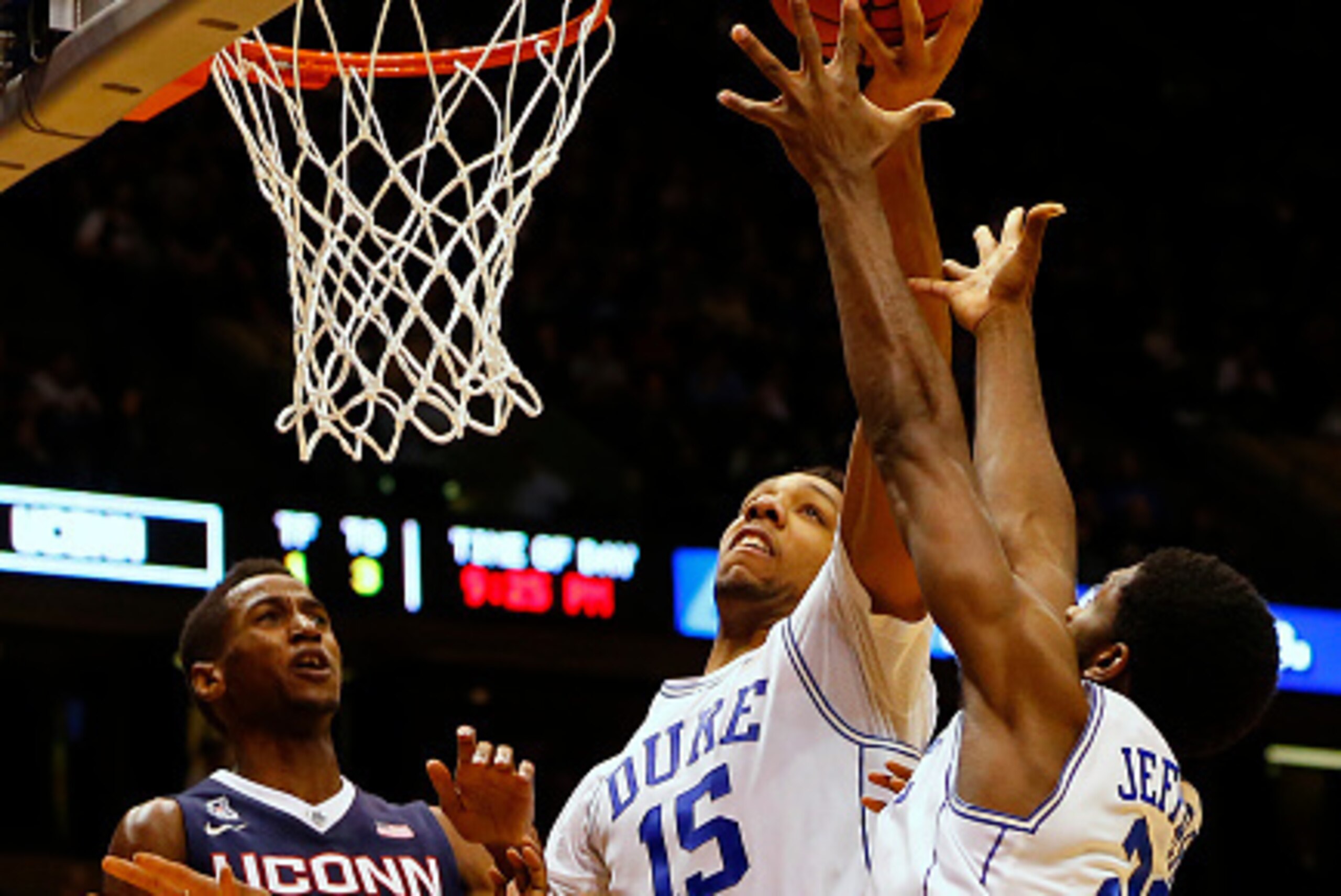 EAST RUTHERFORD, NJ - DECEMBER 18: Jahlil Okafor #15 grabs a rebound with help from teammate Amile Jefferson #21 of the Duke Blue Devils as Kentan Facey #12 and Phillip Nolan #1 of the Connecticut Huskies look on during the second half of an NCAA college 