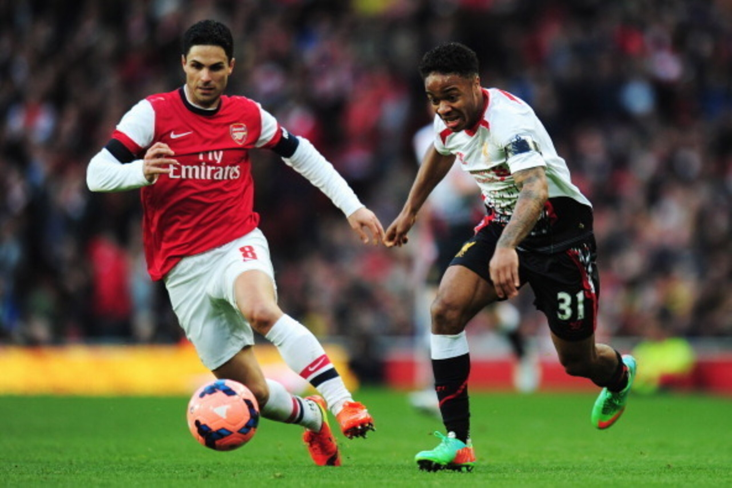 LONDON, ENGLAND - FEBRUARY 16:  Raheem Sterling (R) of Liverpool holds off the challenge of Mikel Arteta (L) of Arsenal during the FA Cup Fifth Round match between Arsenal and Liverpool at the Emirates Stadium on February 16, 2014 in London, England.  (Ph