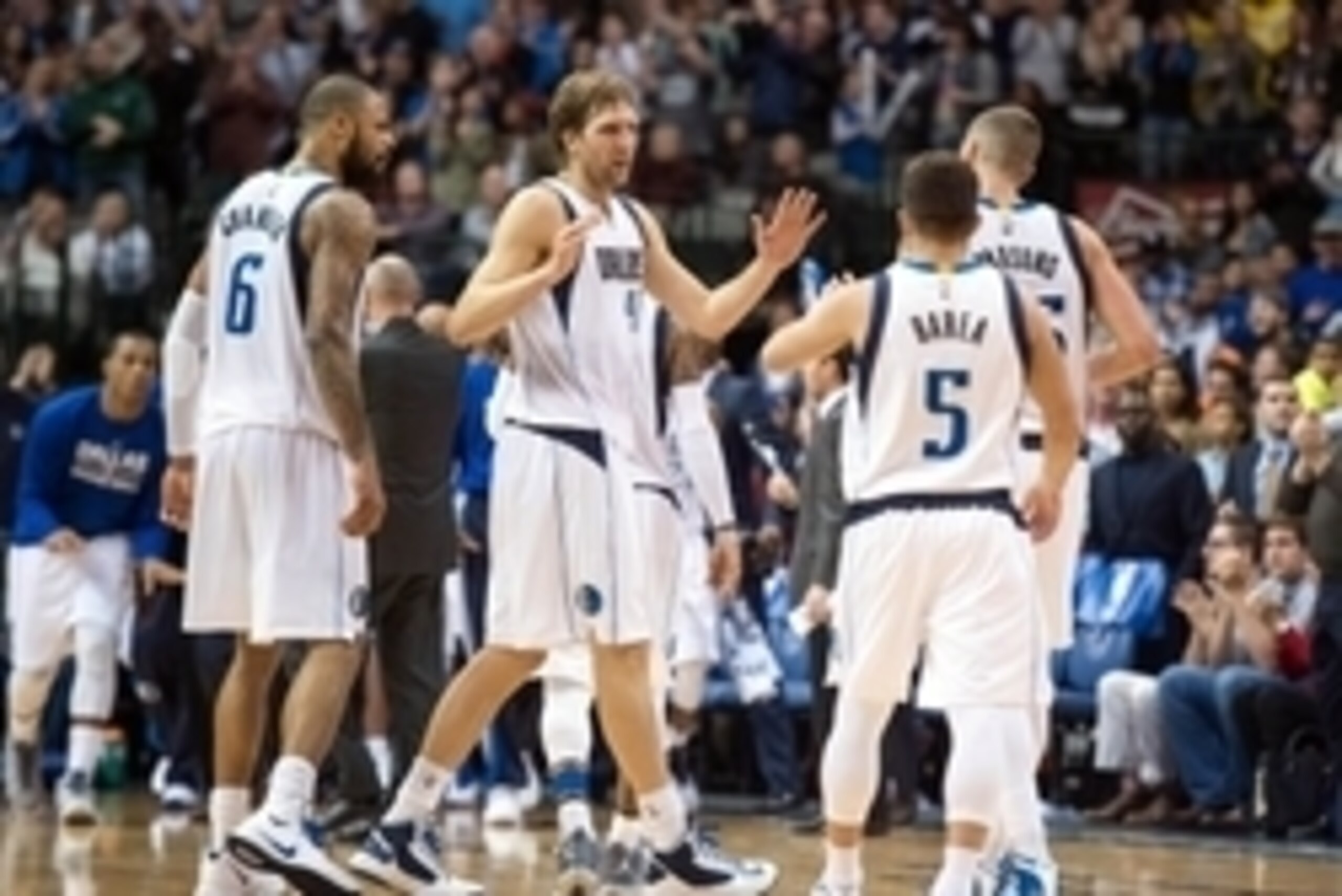 Nov 26, 2014; Dallas, TX, USA; Dallas Mavericks center Tyson Chandler (6) and forward Dirk Nowitzki (41) and guard J.J. Barea (5) and forward Chandler Parsons (25) celebrate during overtime against the New York Knicks at the American Airlines Center. The 