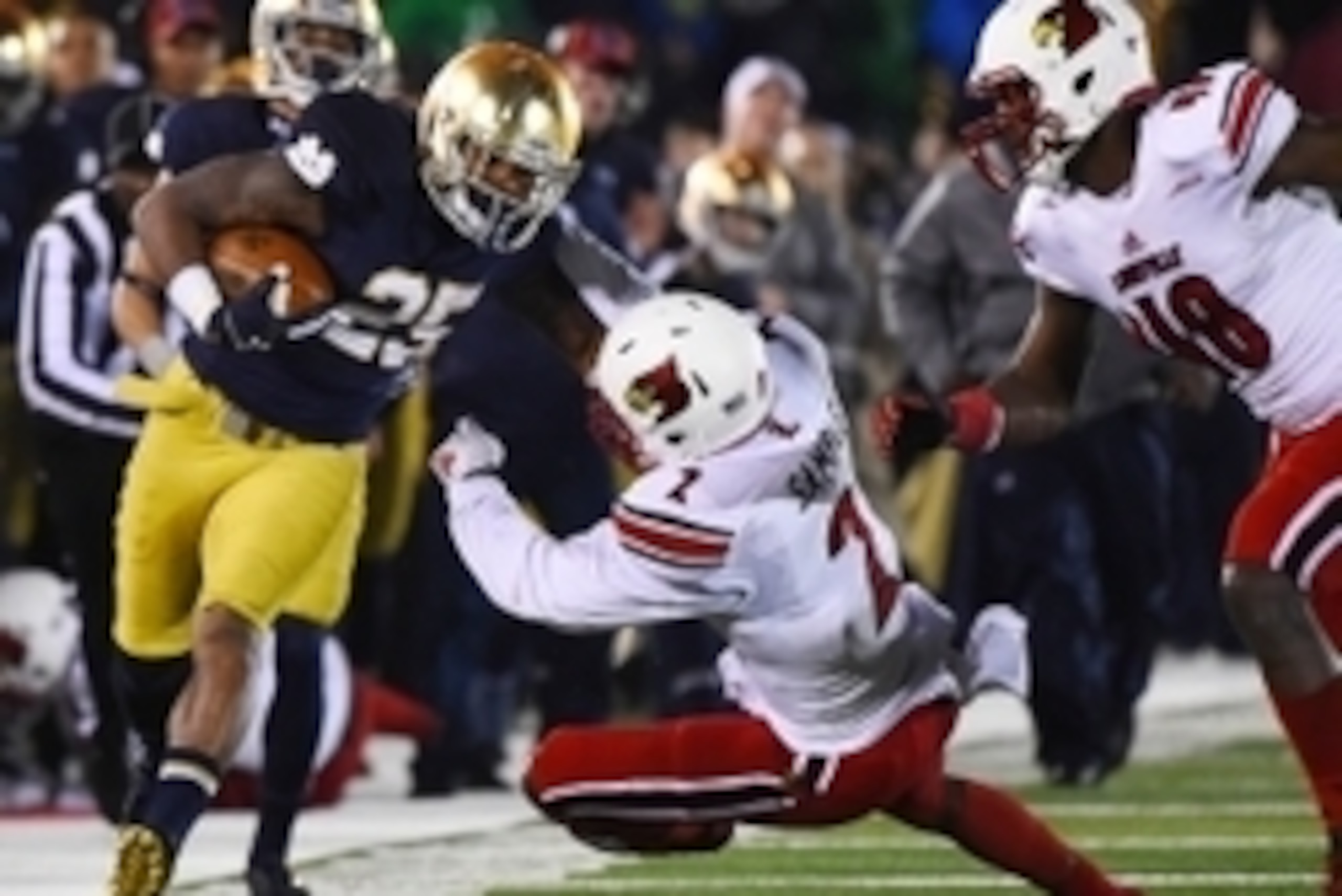 Nov 22, 2014; South Bend, IN, USA;  Notre Dame Fighting Irish running back Tarean Folston (25) rushes the ball against Louisville Cardinals safety James Sample (2) during the fourth quarter at Notre Dame Stadium. The Louisville Cardinals defeat Notre Dame
