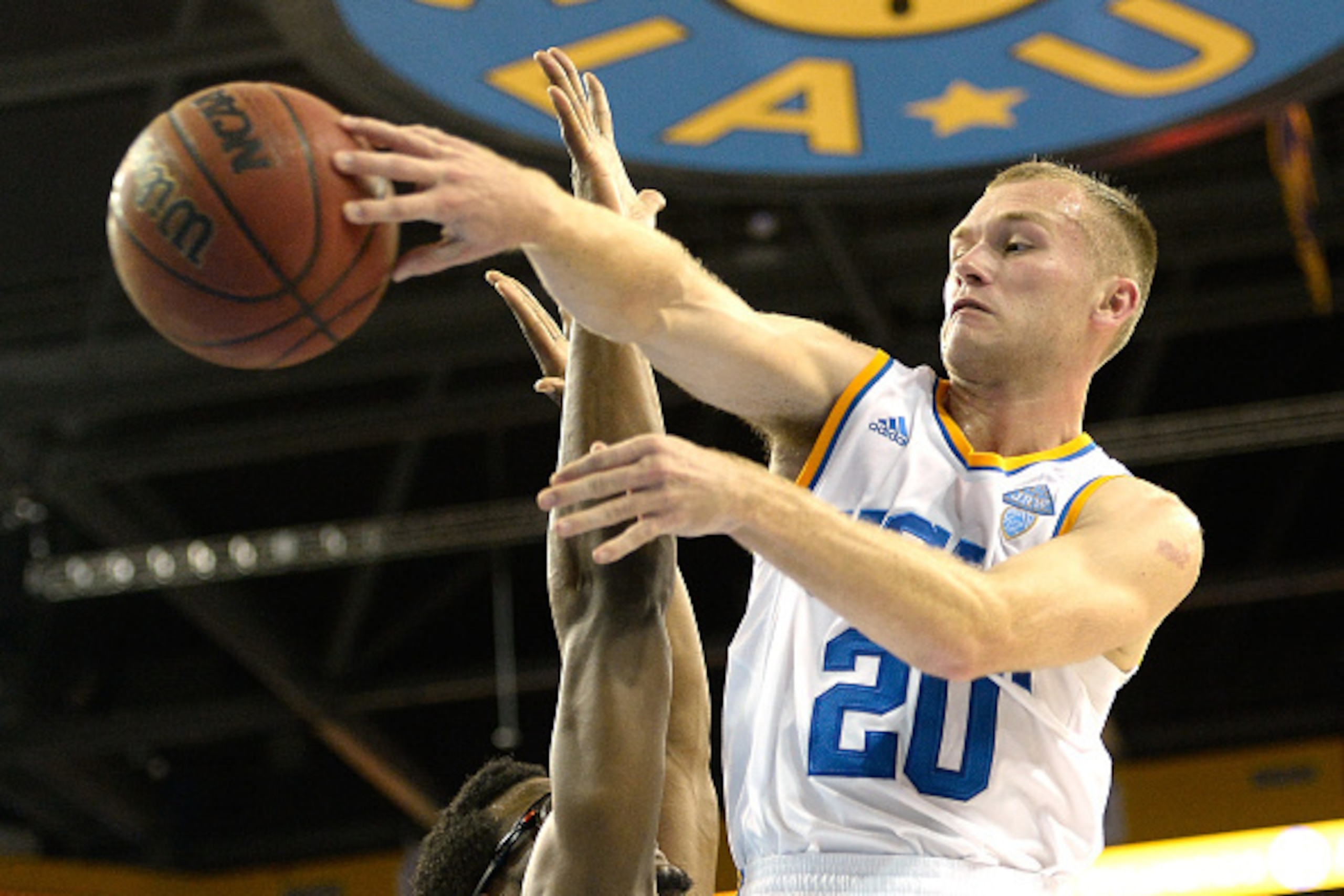 LOS ANGELES, CA - DECEMBER 03:  Bryce Alford #20 of the UCLA Bruins makes a pass around Alex Harris #23 of the Cal State Fullerton Titans at Pauley Pavilion on December 3, 2014 in Los Angeles, California.  UCLA won 73-45.  (Photo by Harry How/Getty Images