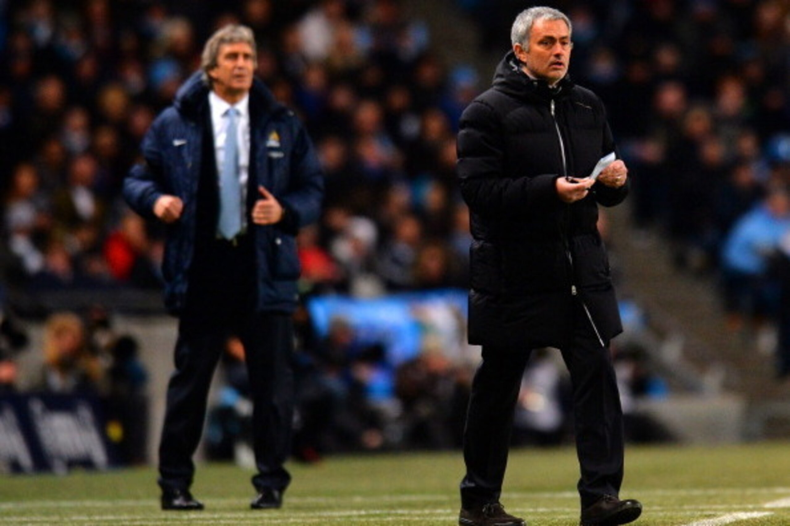 MANCHESTER, ENGLAND - FEBRUARY 03: Manuel Pellegrini manager of Manchester City and Jose Mourinho manager of Chelsea give instructions during the Barclays Premier League match between Manchester City and Chelsea at Etihad Stadium on February 3, 2014 in Ma