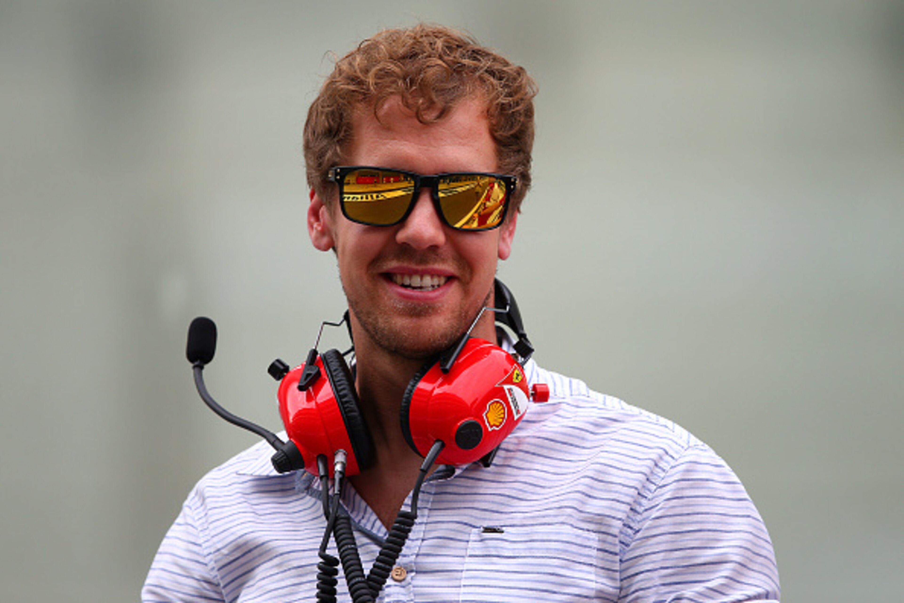 ABU DHABI, UNITED ARAB EMIRATES - NOVEMBER 25: Sebastian Vettel of Germany and Infiniti Red Bull Racing smiles as he speaks with members of the Ferrari team on the pit wall during day one of Formula One testing at Yas Marina Circuit on November 25, 2014 ABU DHABI, UNITED ARAB EMIRATES - NOVEMBER 25: Sebastian Vettel of Germany and Infiniti Red Bull Racing smiles as he speaks with members of the Ferrari team on the pit wall during day one of Formula One testing at Yas Marina Circuit on November 25, 2014