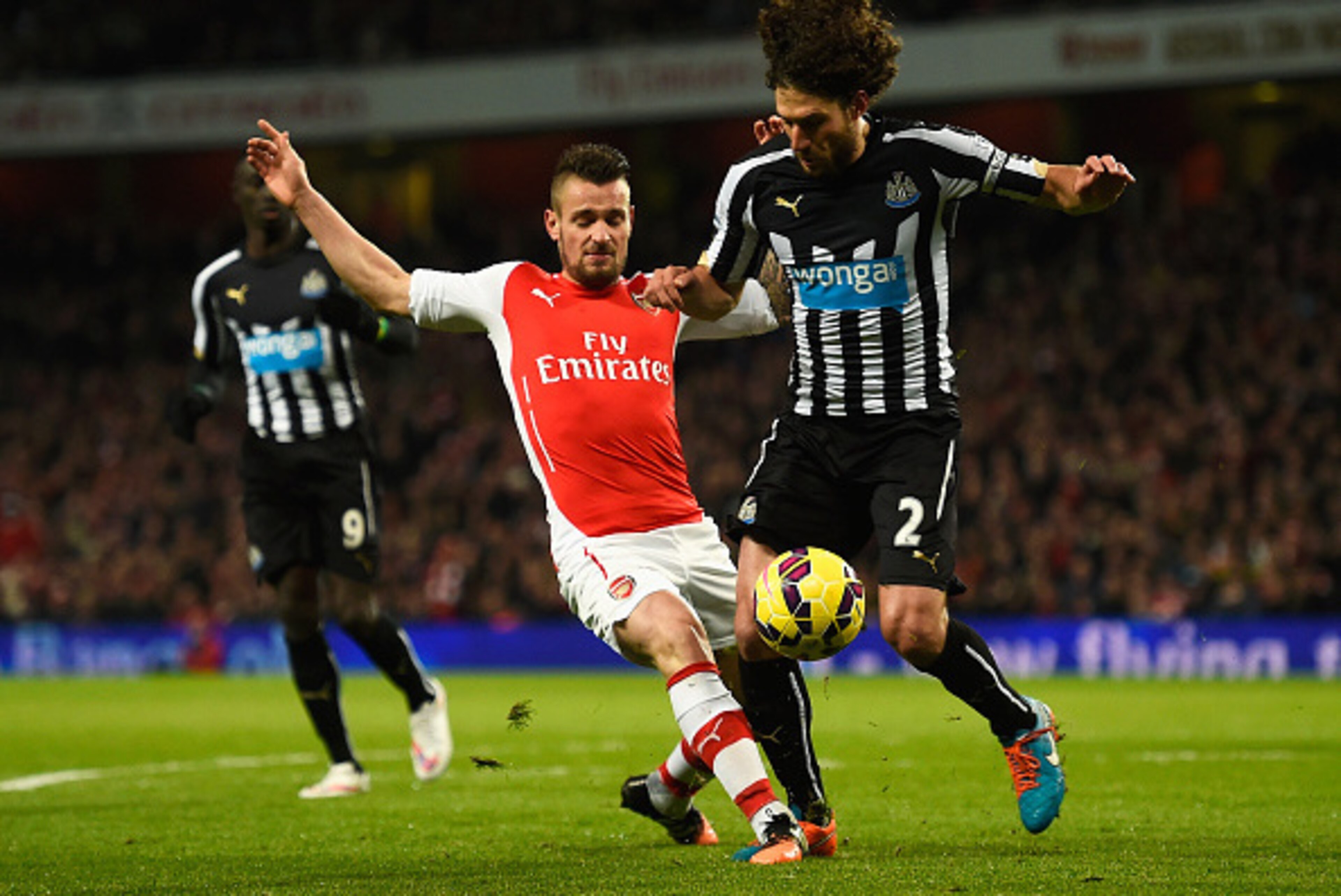 LONDON, ENGLAND - DECEMBER 13: Mathieu Debuchy of Arsenal tackles Fabricio Coloccini of Newcastle United during the Barclays Premier League match between Arsenal and Newcastle United at Emirates Stadium on December 13, 2014 in London, England.  (Photo by 
