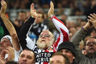 NEWCASTLE UPON TYNE, ENGLAND - DECEMBER 21:  A fan supporting both teams applauds during the Barclays Premier League match between Newcastle United and Sunderland at St James' Park on December 21, 2014 in Newcastle upon Tyne, England.  (Photo by Laurence 