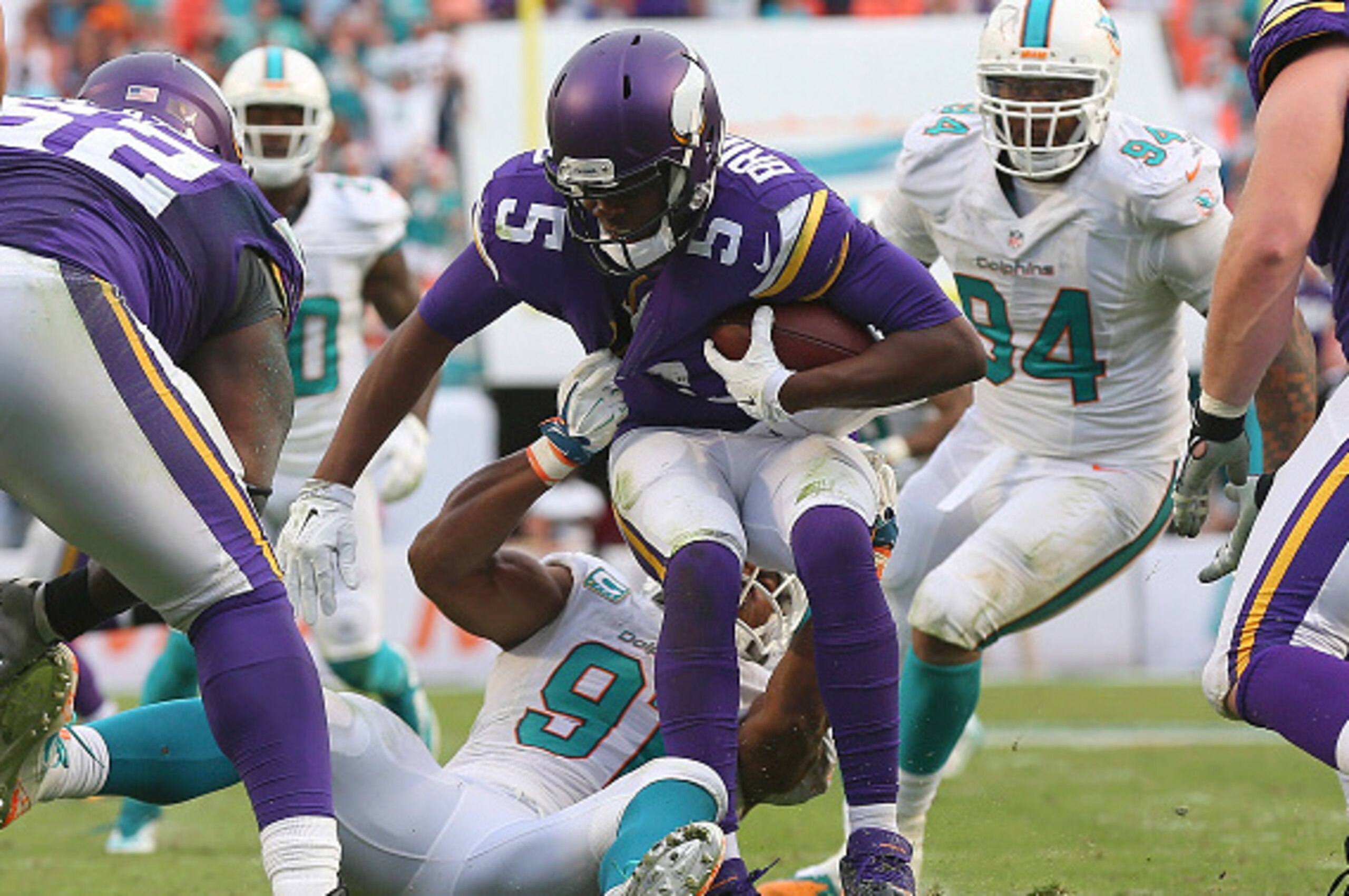 MIAMI GARDENS, FL - DECEMBER 21:  Quarterback Teddy Bridgewater #5 of the Minnesota Vikings is sacked by defensive end Cameron Wake #91 of the Miami Dolphins in the fourth quarter during a game at Sun Life Stadium on December 21, 2014 in Miami Gardens, Fl