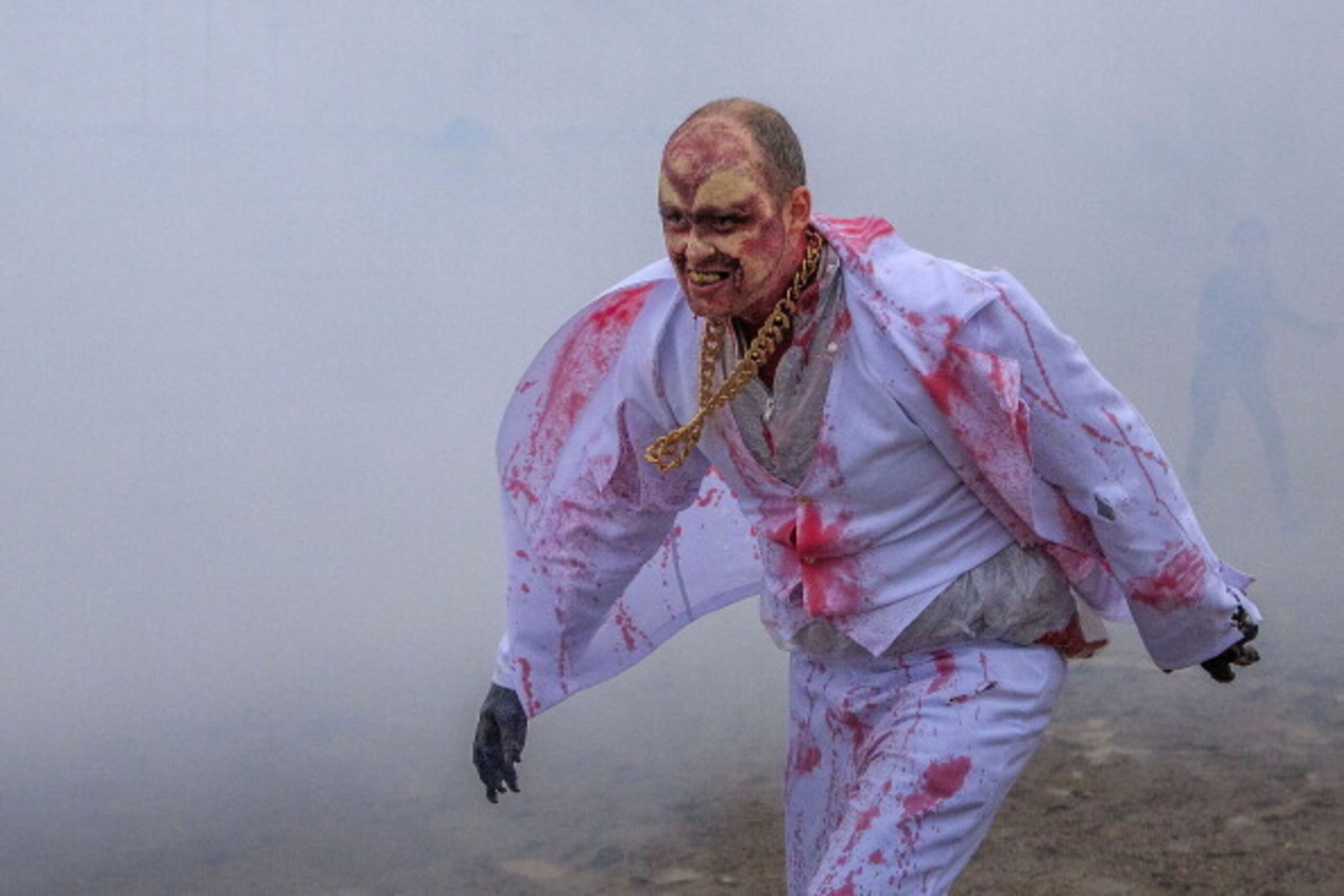 BERLIN, GERMANY - MAY 18:  A zombie clown prepares to catch the runners as he takes part in the 'Zombie Run' on May 18, 2014 in Berlin, Germany. The race sees participants attempt to complete a 5 kilometre cross-country run,  overcoming a series of obstac