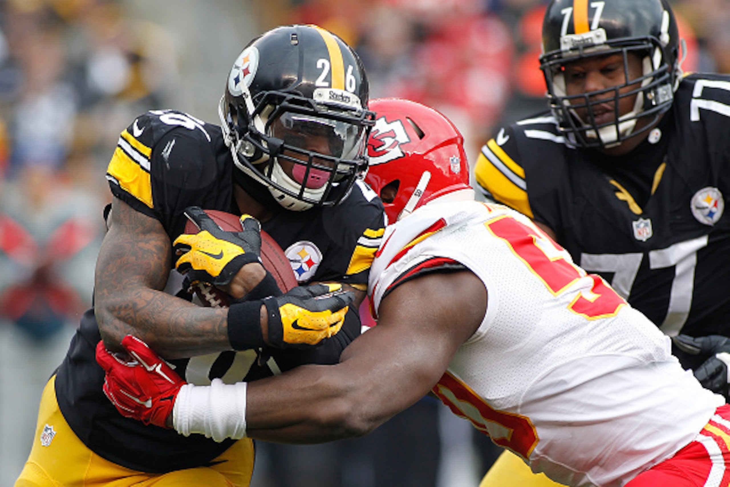 PITTSBURGH, PA - DECEMBER 21:  Le'Veon Bell #26 of the Pittsburgh Steelers gets wrapped up by Jamell Fleming #30 of the Kansas City Chiefs during the second quarter at Heinz Field on December 21, 2014 in Pittsburgh, Pennsylvania.  (Photo by Justin K. Alle