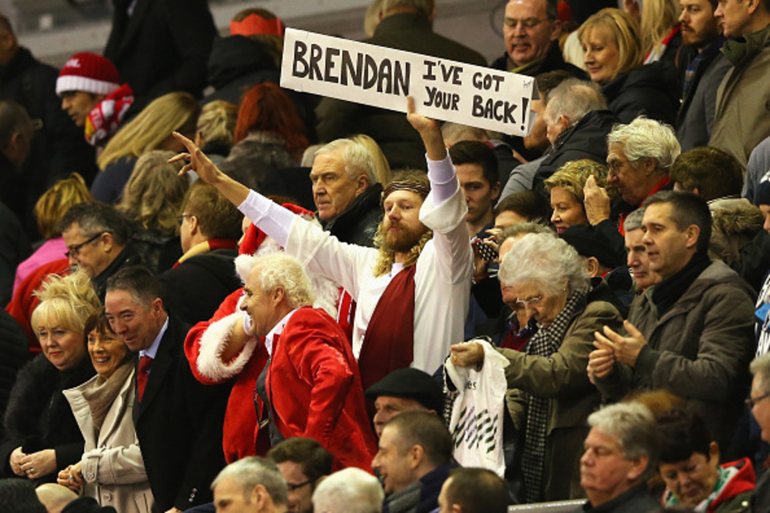 LIVERPOOL, ENGLAND - DECEMBER 21: Fans dressed as Father Christmas and Jesus display a sign for Brendan Rodgers, manager of Liverpool during the Barclays Premier League match between Liverpool and Arsenal at Anfield on December 21, 2014 in Liverpool, Eng LIVERPOOL, ENGLAND - DECEMBER 21: Fans dressed as Father Christmas and Jesus display a sign for Brendan Rodgers, manager of Liverpool during the Barclays Premier League match between Liverpool and Arsenal at Anfield on December 21, 2014 in Liverpool, Eng