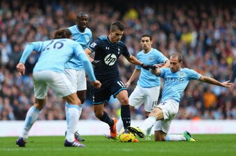 MANCHESTER, ENGLAND - NOVEMBER 24: Erik Lamela of Tottenham Hotspur is tackled by Pablo Zabaleta of Manchester City during the Barclays Premier League match between Manchester City and Tottenham Hotspur at Etihad Stadium on November 24, 2013 in Manchester