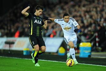 SWANSEA, WALES - DECEMBER 14:  Spurs player Erik Lamela (l) challenges Swansea player Jefferson Montero during the Barclays Premier League match between Swansea City and Tottenham Hotspur at Liberty Stadium on December 14, 2014 in Swansea, Wales.  (Photo 