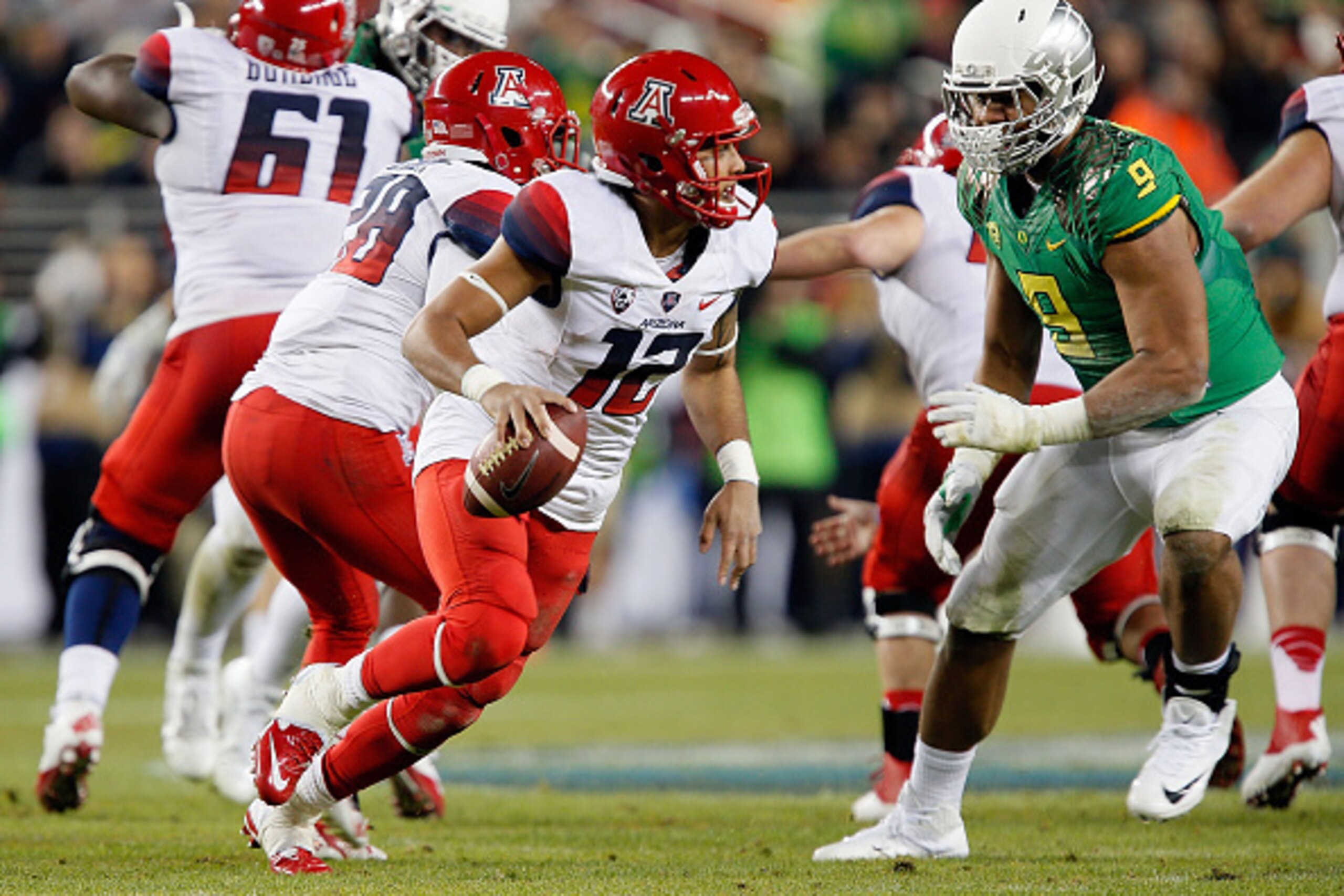 SANTA CLARA, CA - DECEMBER 05: Anu Solomon #12 of the Arizona Wildcats looks to escape the defense of Arik Armstead #9 of the Oregon Ducks during the PAC-12 Championships at Levi's Stadium on December 5, 2014 in Santa Clara, California. (Photo by Brian Ba
