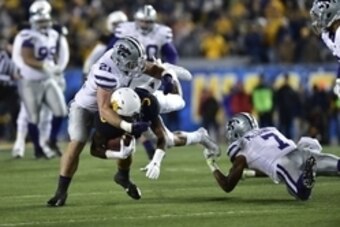 Nov 20, 2014; Morgantown, WV, USA; West Virginia Mountaineers wide receiver Mario Alford (5) with the ball as Kansas State Wildcats linebacker Jonathan Truman (21) and Kansas State Wildcats defensive back Danzel McDaniel (7) defend in the second quarter a