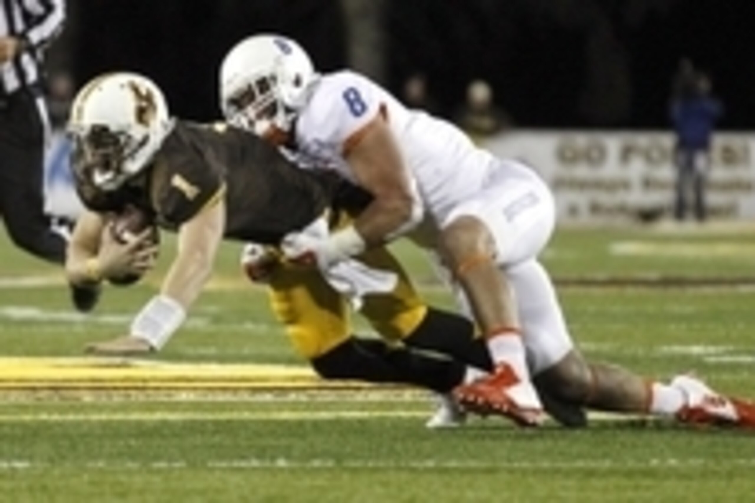 Nov 22, 2014; Laramie, WY, USA; Wyoming Cowboys quarterback Sam Stratton (1) is tackled by Boise State Broncos lineman Kamalei Correa (8) during the third quarter at War Memorial Stadium. Mandatory Credit: Troy Babbitt-USA TODAY Sports