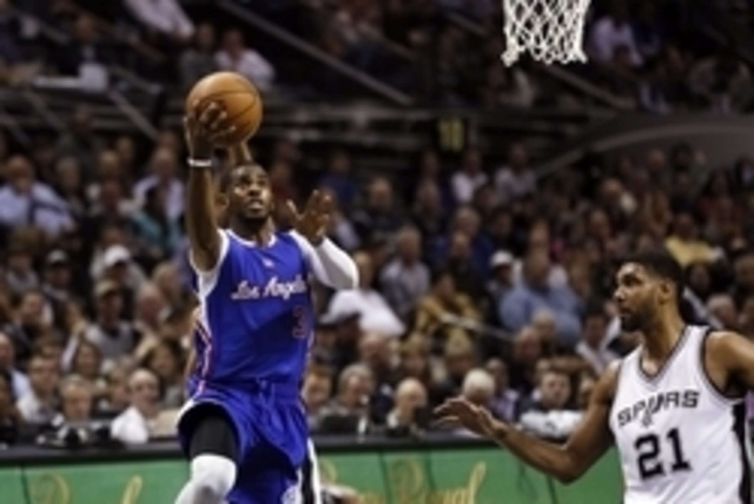 Dec 22, 2014; San Antonio, TX, USA; Los Angeles Clippers point guard Chris Paul (3) shoots the ball as San Antonio Spurs power forward Tim Duncan (21) looks on during the second half at AT&T Center. Mandatory Credit: Soobum Im-USA TODAY Sports