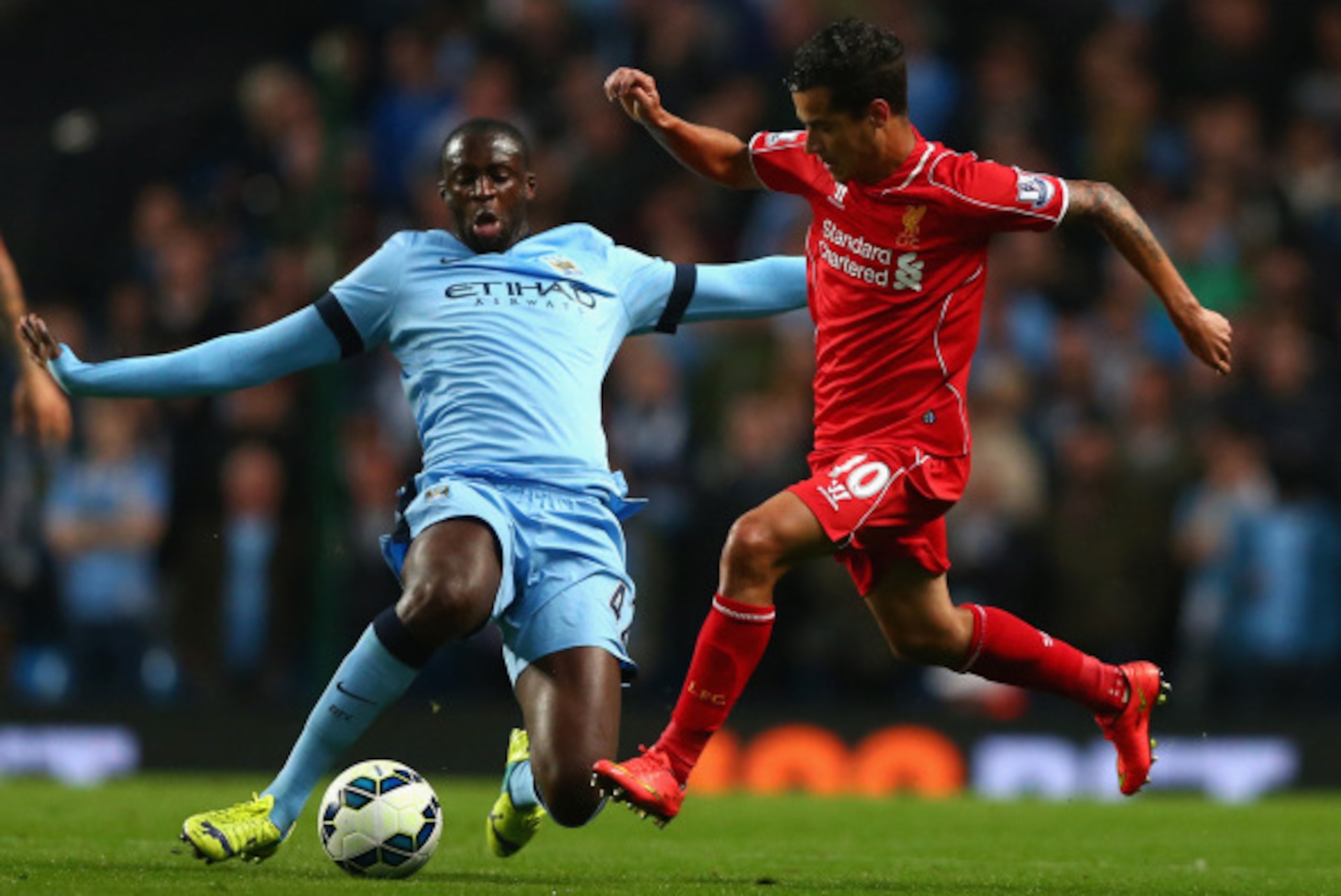 MANCHESTER, ENGLAND - AUGUST 25:  Philippe Coutinho of Liverpool competes with Yaya Toure of Manchester City during the Barclays Premier League match between Manchester City and Liverpool at the Etihad Stadium on August 25, 2014 in Manchester, England.  (