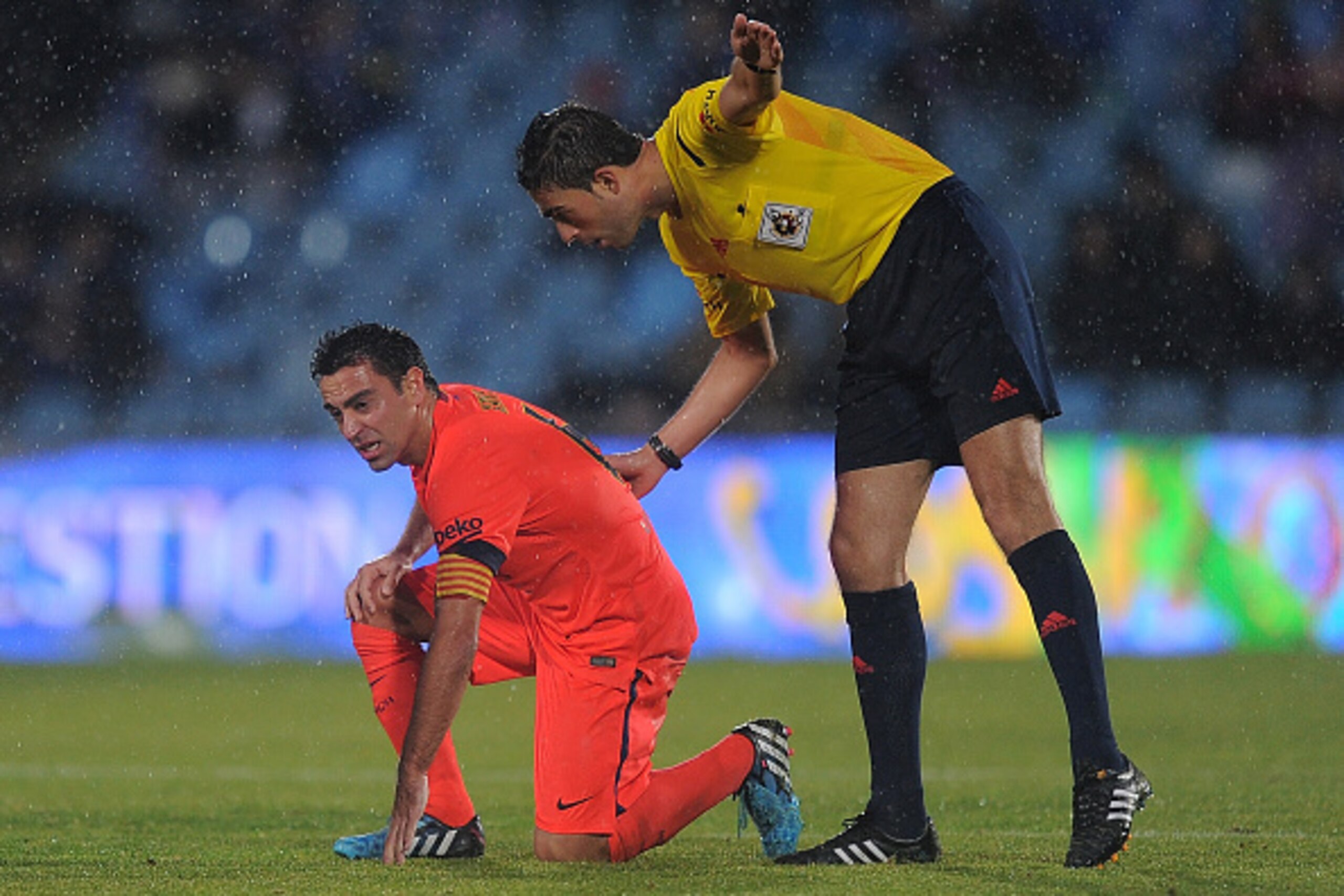 GETAFE, SPAIN - DECEMBER 13:  Referee Vicandi Garrido checks up on Xavi Hernandez of FC Barcelona after he was fouled during the La Liga match between Getafe CF and FC Barcelona at the Alfonso Perez stadium on December 13, 2014 in Getafe, Spain.  (Photo b