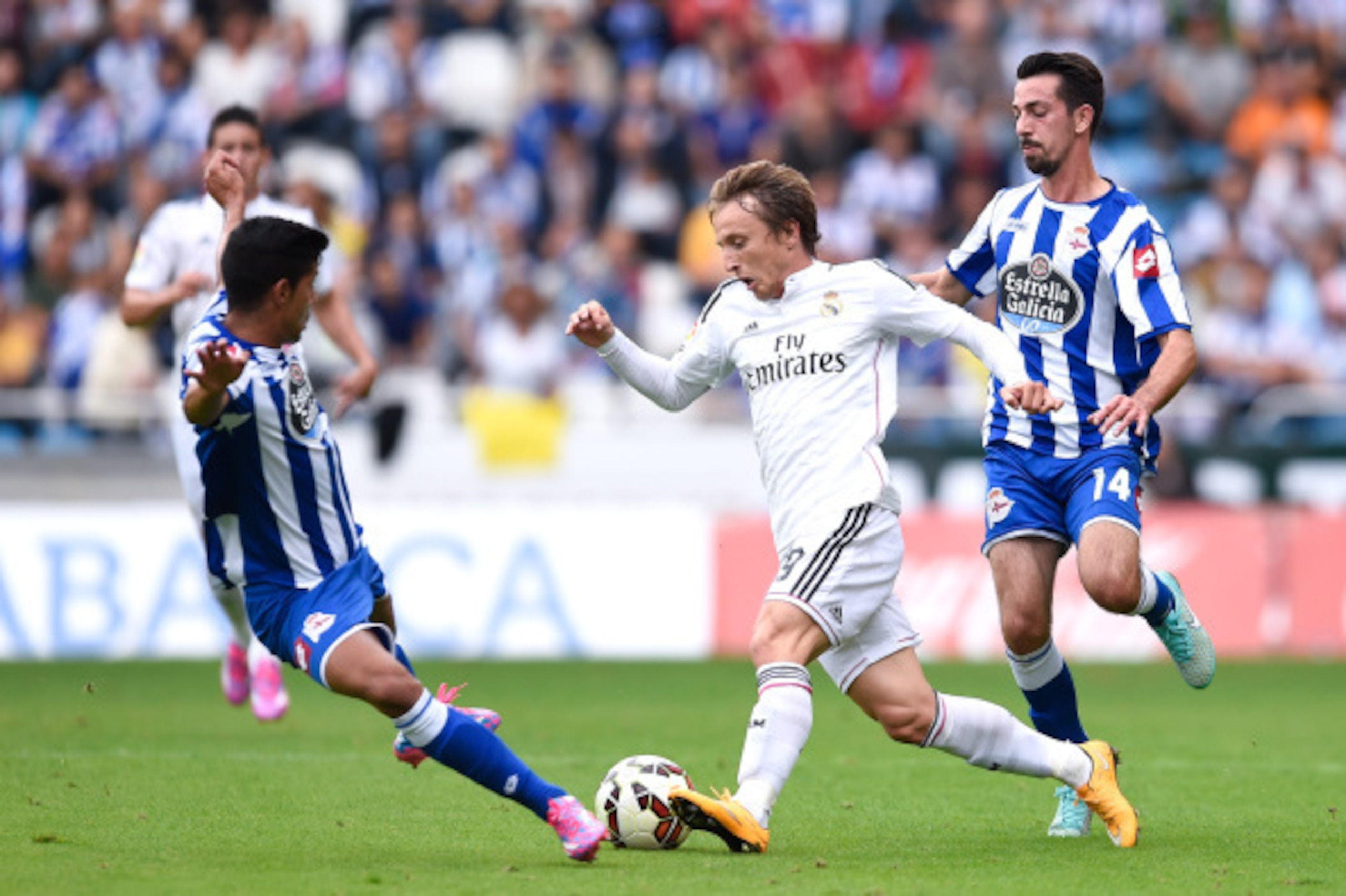 LA CORUNA, SPAIN - SEPTEMBER 20:  Luka Modric of Real Madrid CF competes for the ball with Juanfran Moreno (L) and Isaac Cuenca of RC Deportivo La Coruna during the La Liga match between RC Deportivo La Coruna and Real Madrid CF at Riazor Stadium on Septe