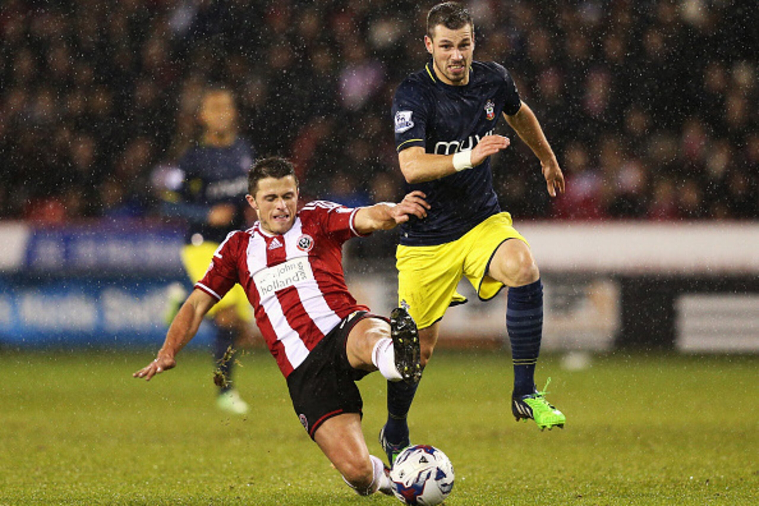 SHEFFIELD, ENGLAND - DECEMBER 16:  Morgan Schneiderlin of Southampton is tackled by Florent Cuvelier of Sheffield United during the Capital One Cup Quarter-Final match between Sheffield United and Southampton at Bramall Lane on December 16, 2014 in Sheffi