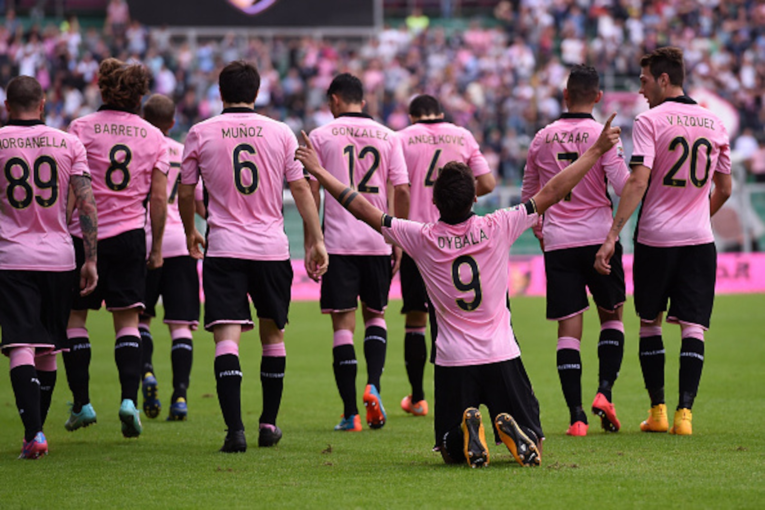 PALERMO, ITALY - NOVEMBER 30:  Paulo Dybala of Palermo celebrates with team mates after scoring the opening goal during the Serie A match between US Citta di Palermo and Parma FC at Stadio Renzo Barbera on November 30, 2014 in Palermo, Italy.  (Photo by T