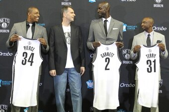 BROOKLYN, NY - July 18: Nets majority owner Mikhail Prokhorov joins Kevin Garnett #2, Paul Pierce #34, and Jason Terry #31 of the Brooklyn Nets during a press conference at the Barclays Center on July 18, 2013 in the Brooklyn borough of New York City.  NO