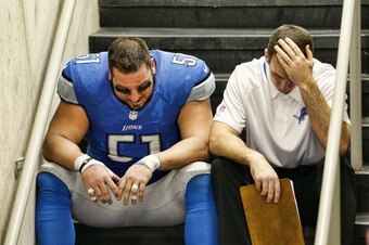 DETROIT, MI - DECEMBER 22: Dominic Raiola #51 of the Detroit Lions sits on the steps with a coach after the Lions lost in over time to the New Yrok Giants at Ford Field on December 22, 2013 in Detroit, Michigan. The Giants defeated the Lions 23-20.  (Phot
