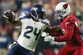 GLENDALE, AZ - DECEMBER 21:  Running back Marshawn Lynch #24 of the Seattle Seahawks pushes off cornerback Patrick Peterson #21 of the Arizona Cardinals to run in a 79 yard touchdown in the fourth quarter during the NFL game at the University of Phoenix S