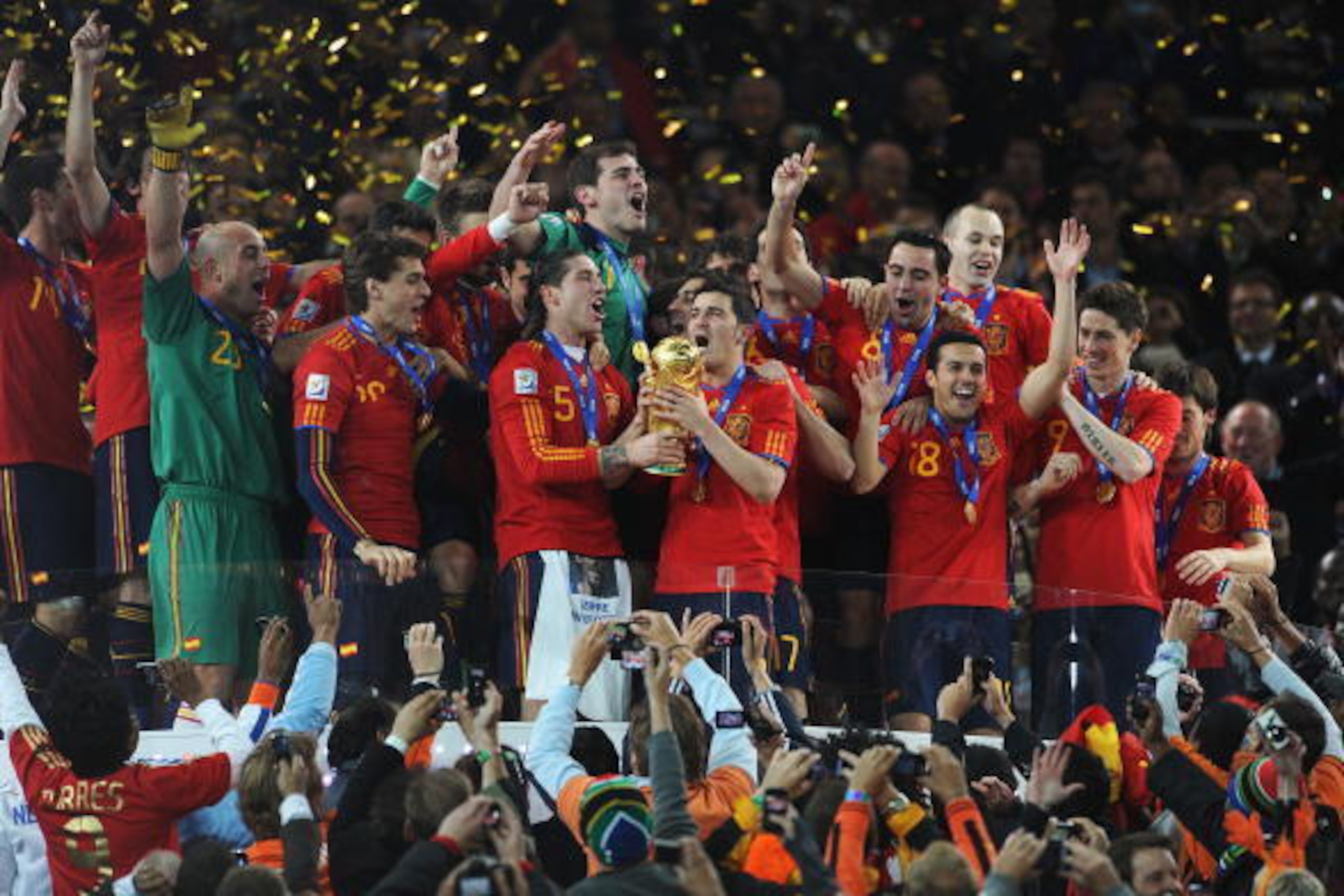 JOHANNESBURG, SOUTH AFRICA - JULY 11:  David Villa and Sergio Ramos of Spain lift the World Cup trophy as the Spain team celebrate victory following the 2010 FIFA World Cup South Africa Final match between Netherlands and Spain at Soccer City Stadium on J