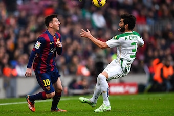 BARCELONA, SPAIN - DECEMBER 20:  Lionel Messi of FC Barcelona competes for the ball with Jose Angel Crespo Rincon of Cordoba CF during the La Liga match between FC Barcelona and Cordoba CF at Camp Nou on December 20, 2014 in Barcelona, Spain.  (Photo by D