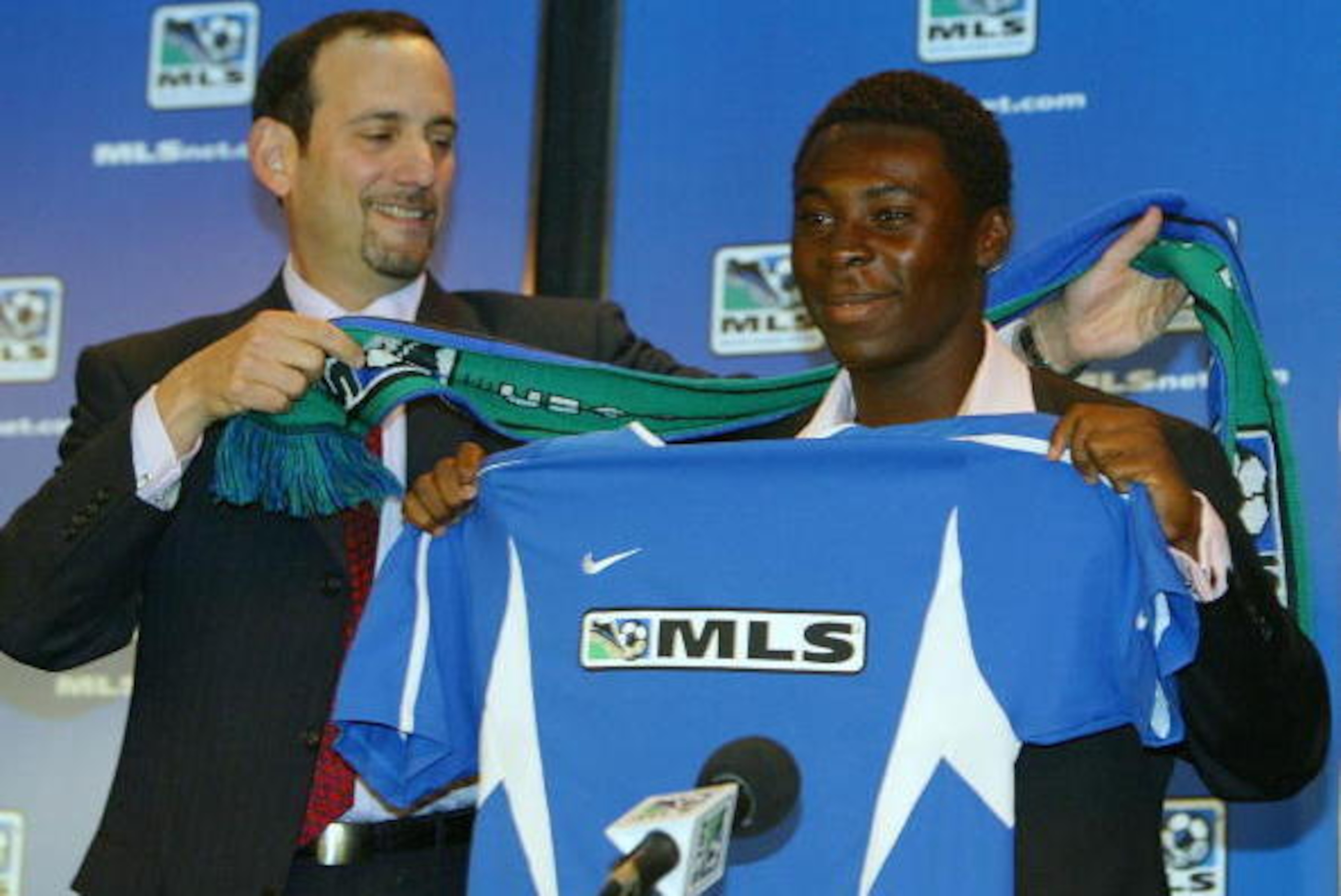 NEW YORK CITY - NOVEMBER 19:  Major League Soccer Commissioner Don Garber gives Freddy Adu a MLS jersey and scarf during a press conference that announce that Adu signed a multi-year contract with MLS on November 19, 2003 at Madison Square Garden in New Y