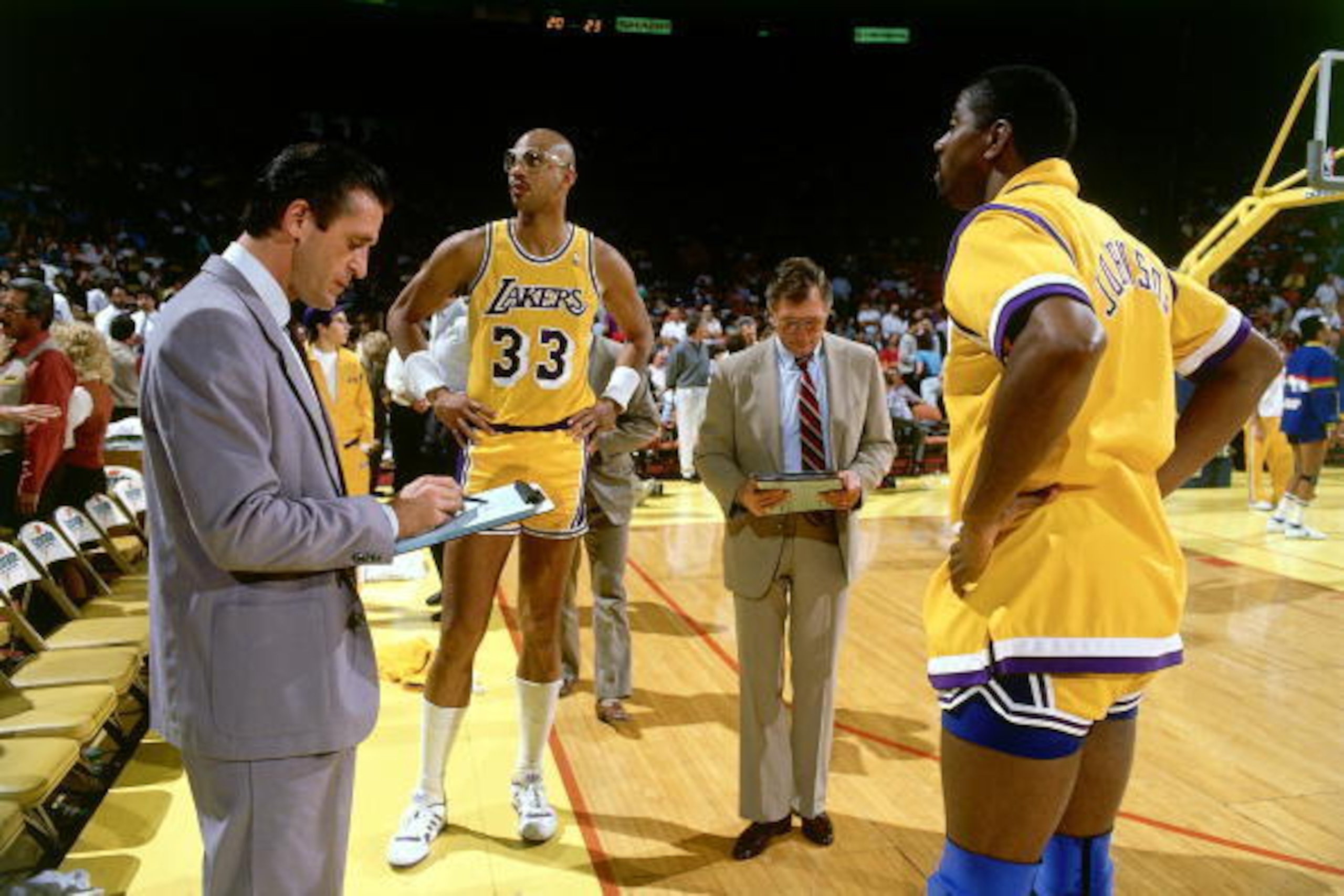 LOS ANGELES -1988:  Head Coach Pat Riley of the Los Angeles Lakers goes over a list of plays with Magic Johnson #32 and Kareem Abdul-Jabbar #33 prior to playing an NBA game at the Forum circa 1988 in Los Angeles, California.  NOTE TO USER: User expressly 