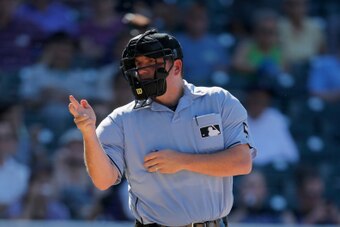 DENVER, CO - SEPTEMBER 17:  Home plate umpire Dan Bellino calls a strike as the Los Angeles Dodgers face the Colorado Rockies at Coors Field on September 17, 2014 in Denver, Colorado. The Rockies defeated the Dodgers 16-2.  (Photo by Doug Pensinger/Getty 