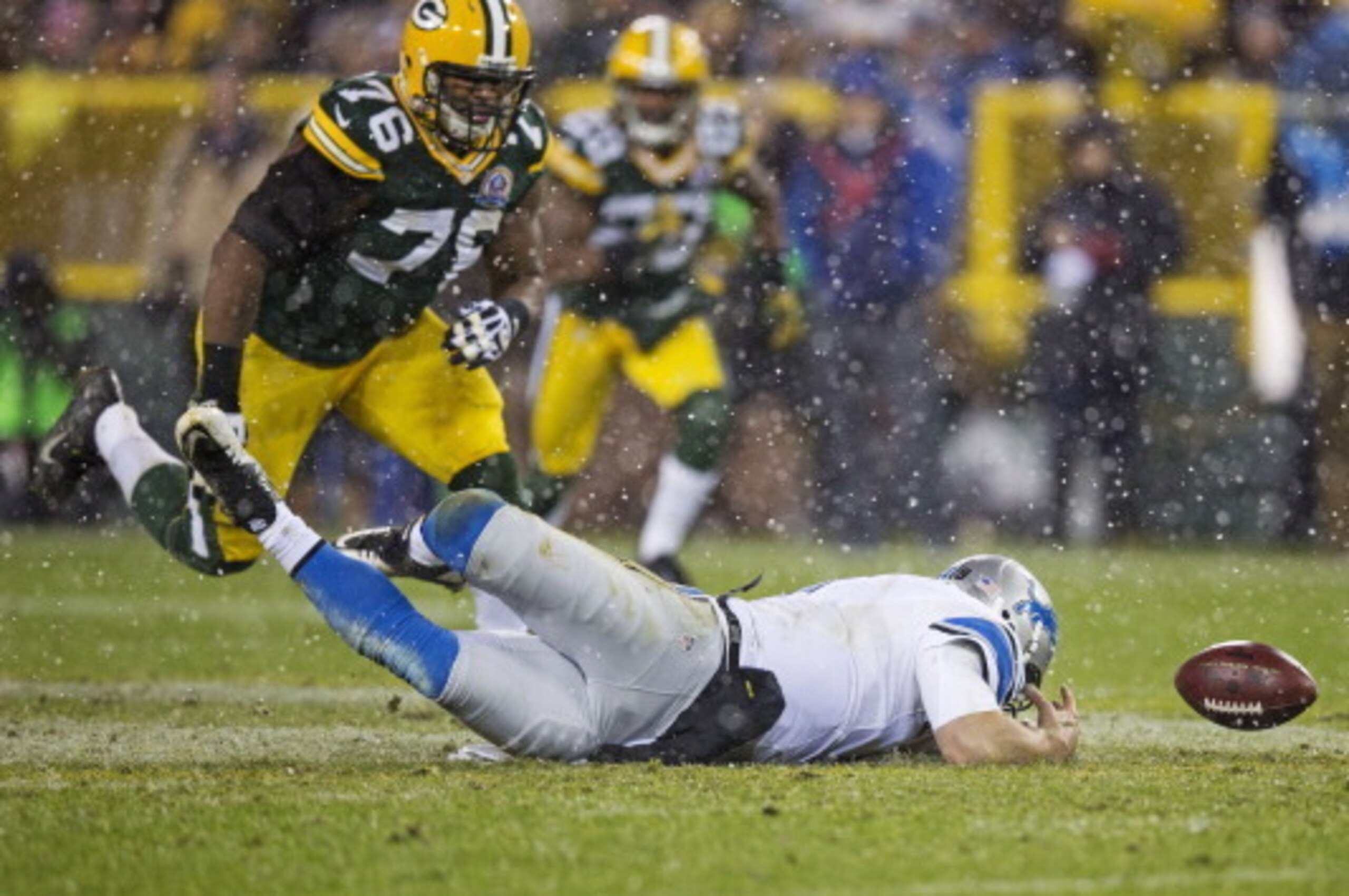 GREEN BAY, WI - DECEMBER 9:  Matthew Stafford #9 of the Detroit Lions dives for the ball he fumbled as Mike Daniels #76 of the Green Bay Packers closes in at Lambeau Field on December 9, 2012 in Green Bay, Wisconsin.  (Photo by Tom Lynn/Getty Images)