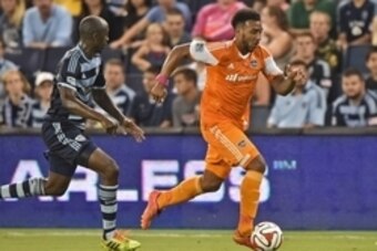Aug 29, 2014; Kansas City, KS, USA; Houston Dynamo forward Giles Barnes(23) brings the ball up field against Sporting KC defender Lawrence Olum (13) during the second half at Sporting Park. Mandatory Credit: Peter G. Aiken-USA TODAY Sports