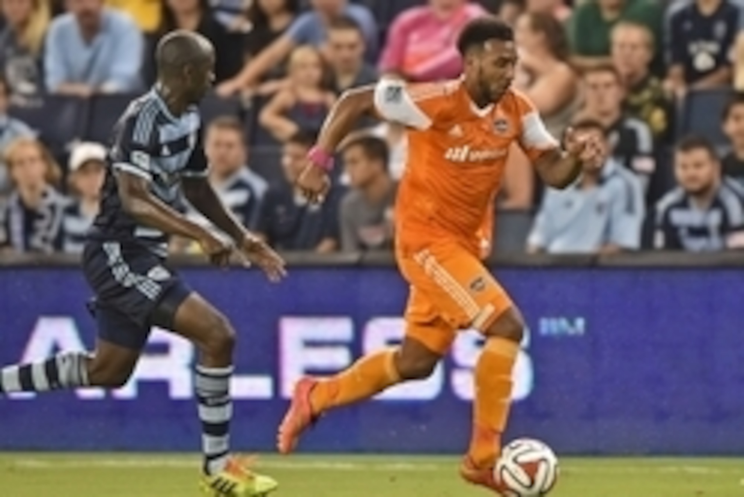 Aug 29, 2014; Kansas City, KS, USA; Houston Dynamo forward Giles Barnes(23) brings the ball up field against Sporting KC defender Lawrence Olum (13) during the second half at Sporting Park. Mandatory Credit: Peter G. Aiken-USA TODAY Sports