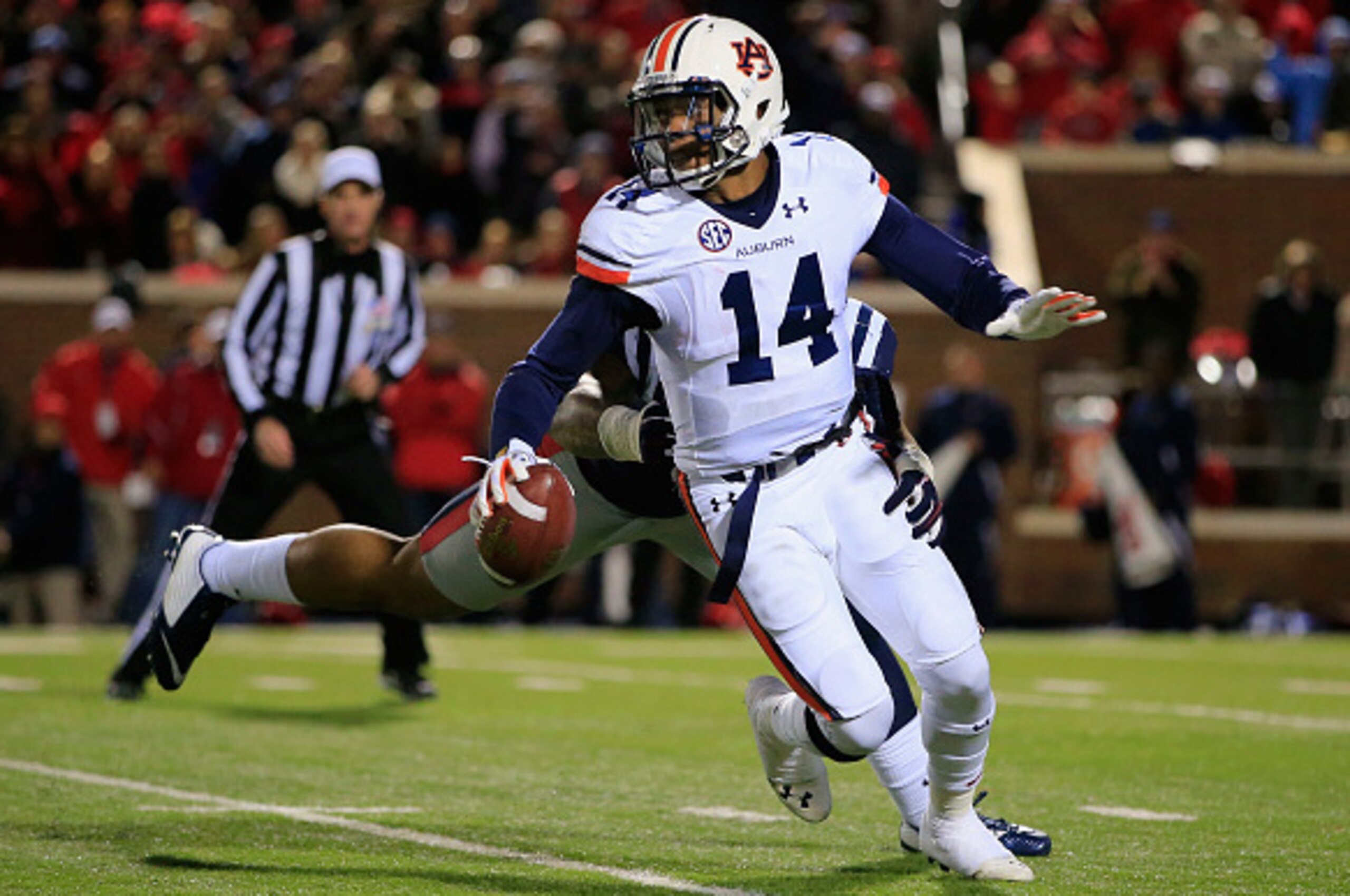 OXFORD, MS - NOVEMBER 01:  Quarterback Nick Marshall #14 of the Auburn Tigers eludes Robert Nkemdiche #5 of the Mississippi Rebels and completes a first down pass in the third quarter at Vaught-Hemingway Stadium on November 1, 2014 in Oxford, Mississippi.