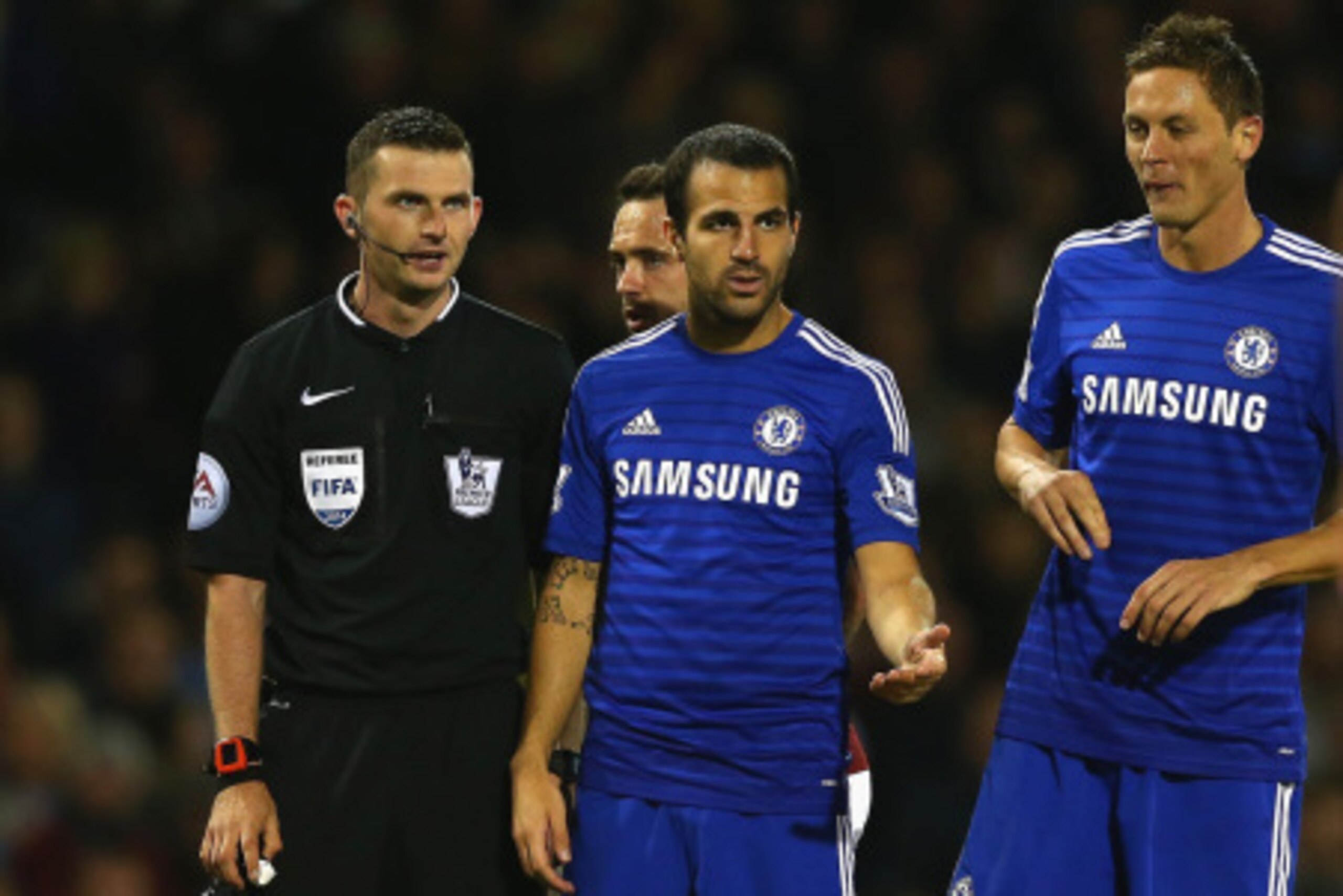 BURNLEY, ENGLAND - AUGUST 18:   Referee Michael Oliver speaks to Cesc Fabregas and Nemanja Matic of Chelsea during the Barclays Premier League match between Burnley and Chelsea at Turf Moor on August 18, 2014 in Burnley, England.  (Photo by Clive Brunskil